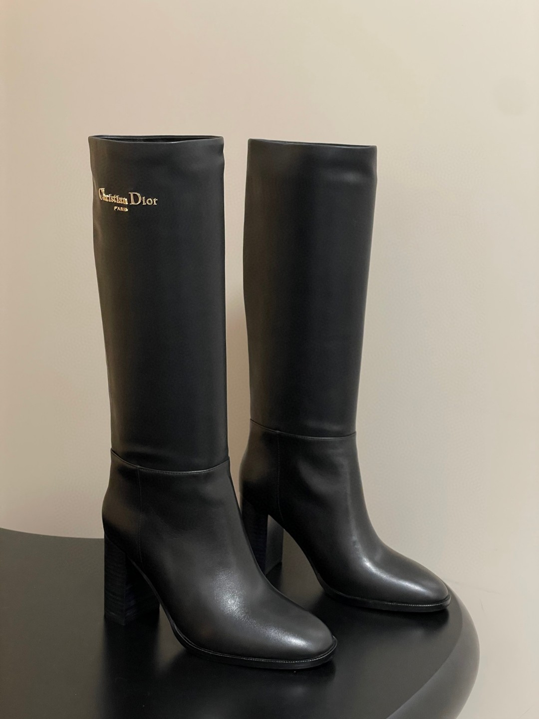 Dior D-Town Heeled Boot in black supple calfskin with a gold-finish metal Christian Dior Paris signature on the side.