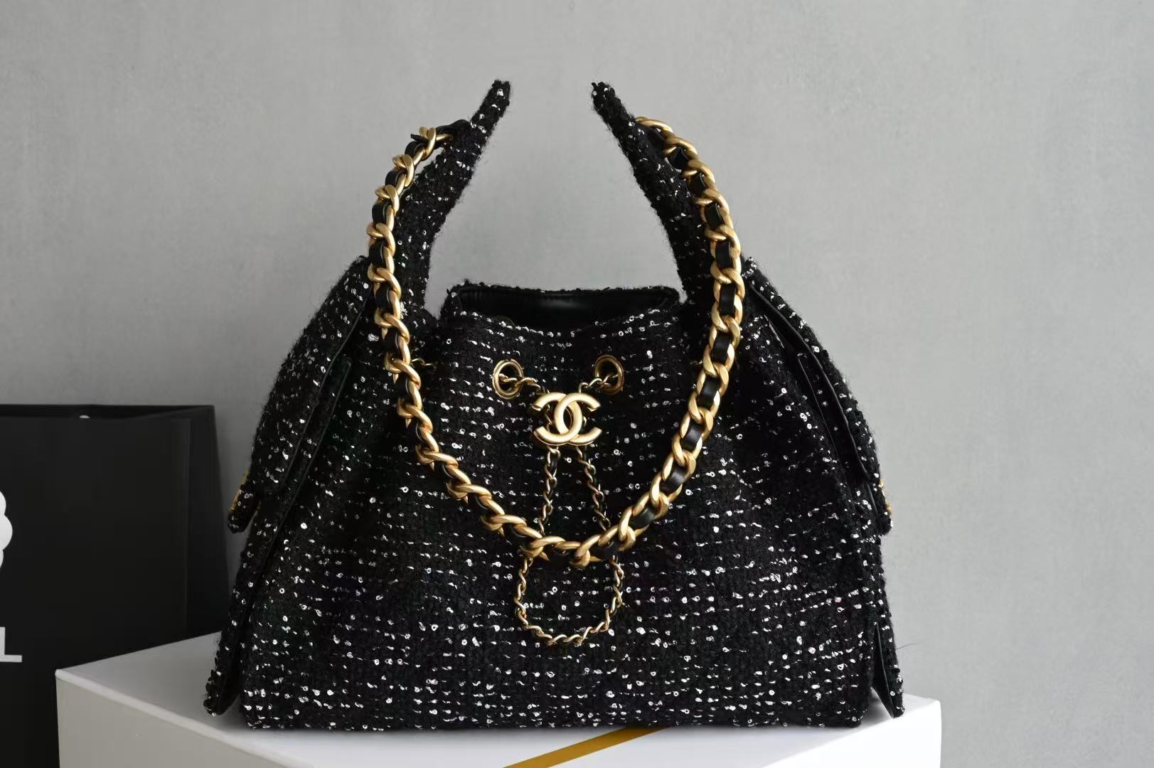 Chanel 25 small handbags black made of wool tweed with gold-tone metal hardware