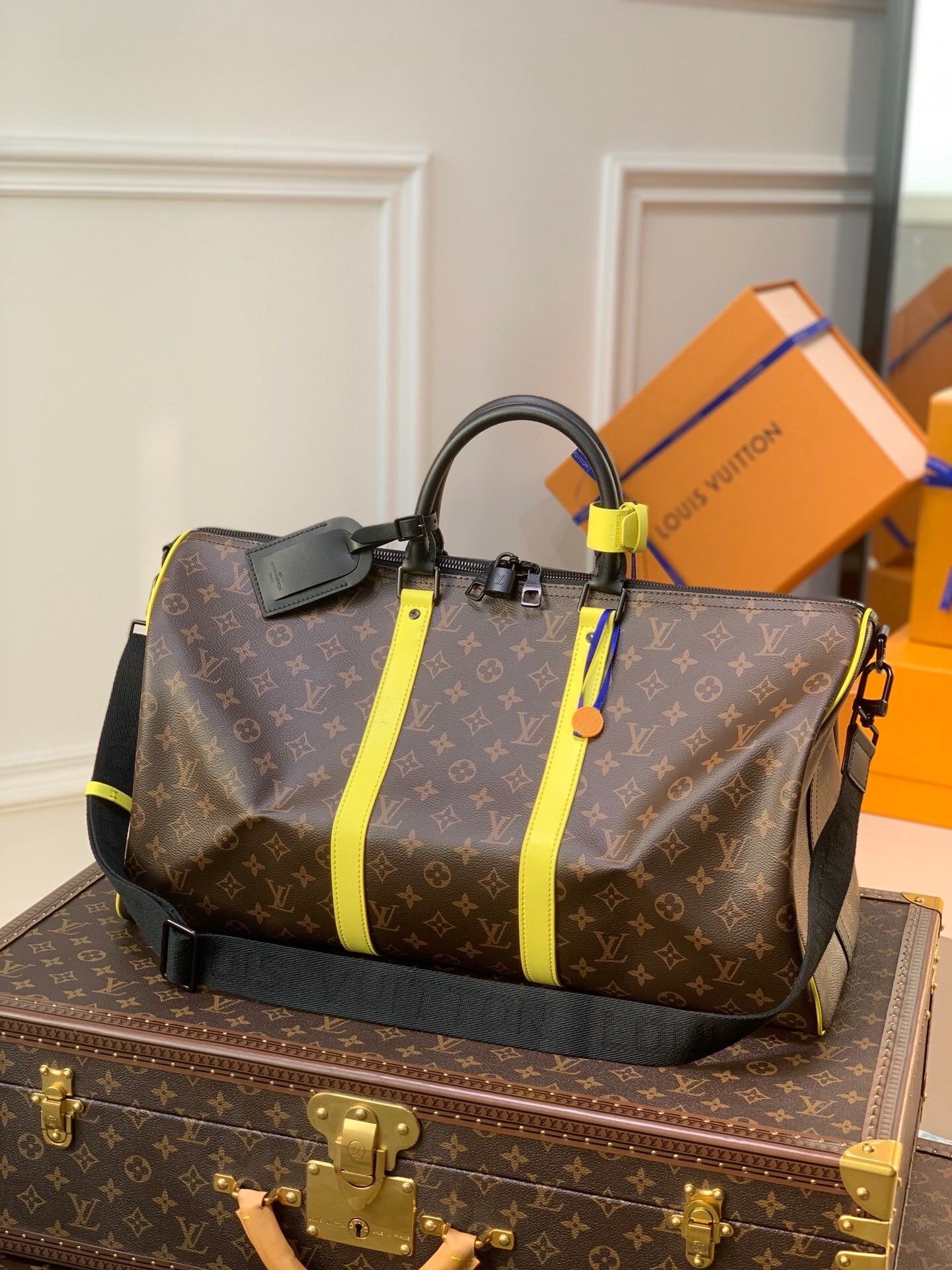 LV Keepall Bandoulière 50 travel bag with yellow stripes.