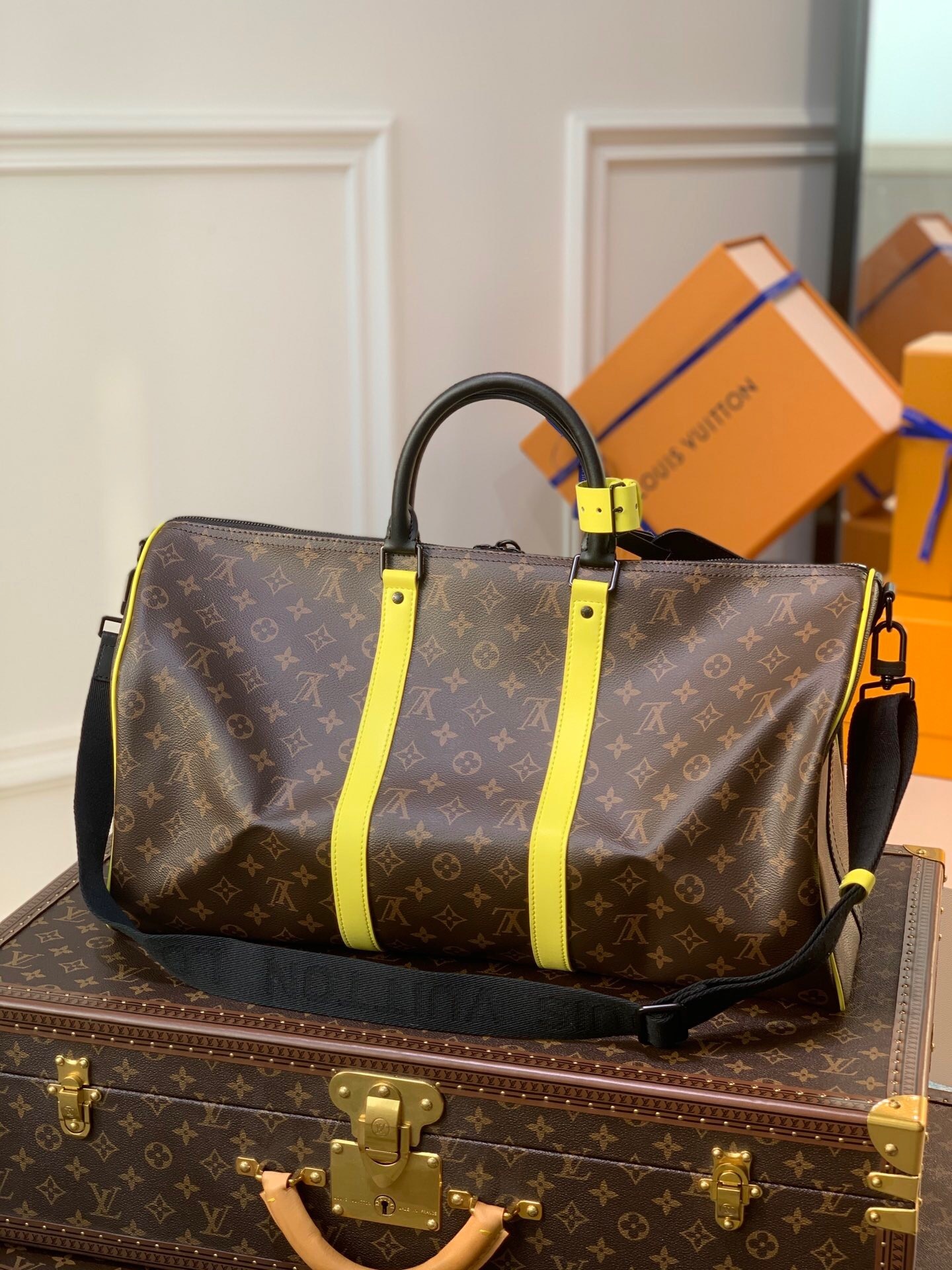 LV Keepall Bandoulière 50 travel bag with yellow stripes.