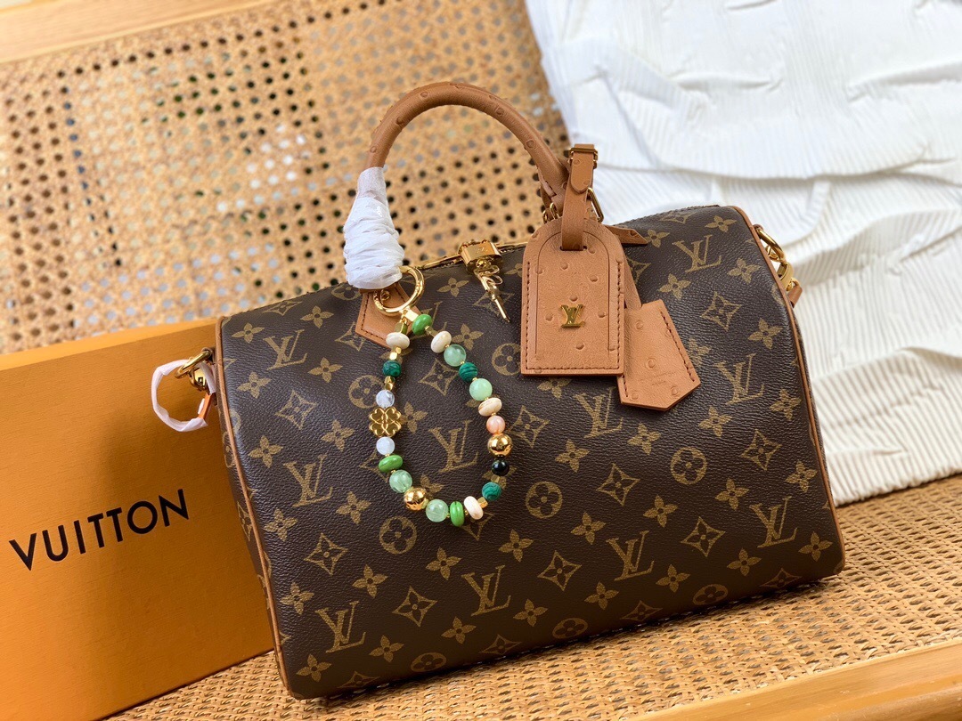 LV Speedy Soft 30 bag in Monogram canvas with a beaded charm and leather trim.