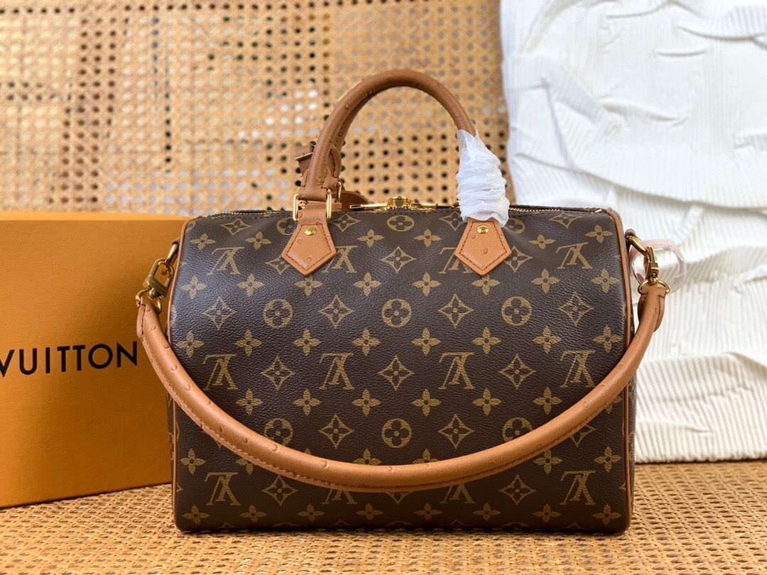 LV Speedy Soft 30 bag in Monogram canvas with a beaded charm and leather trim.