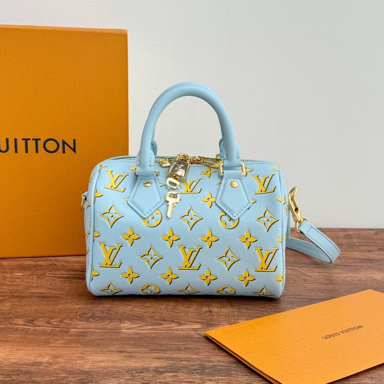LV Speedy Bandoulière 20 handbag in baby blue with a yellow monogram pattern.