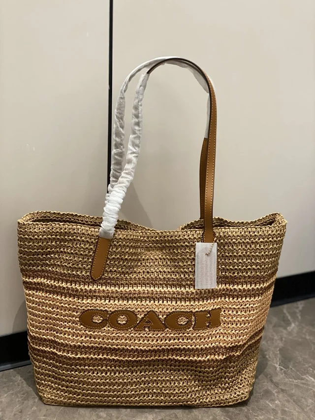 Coach City Tote bag in straw with leather details.