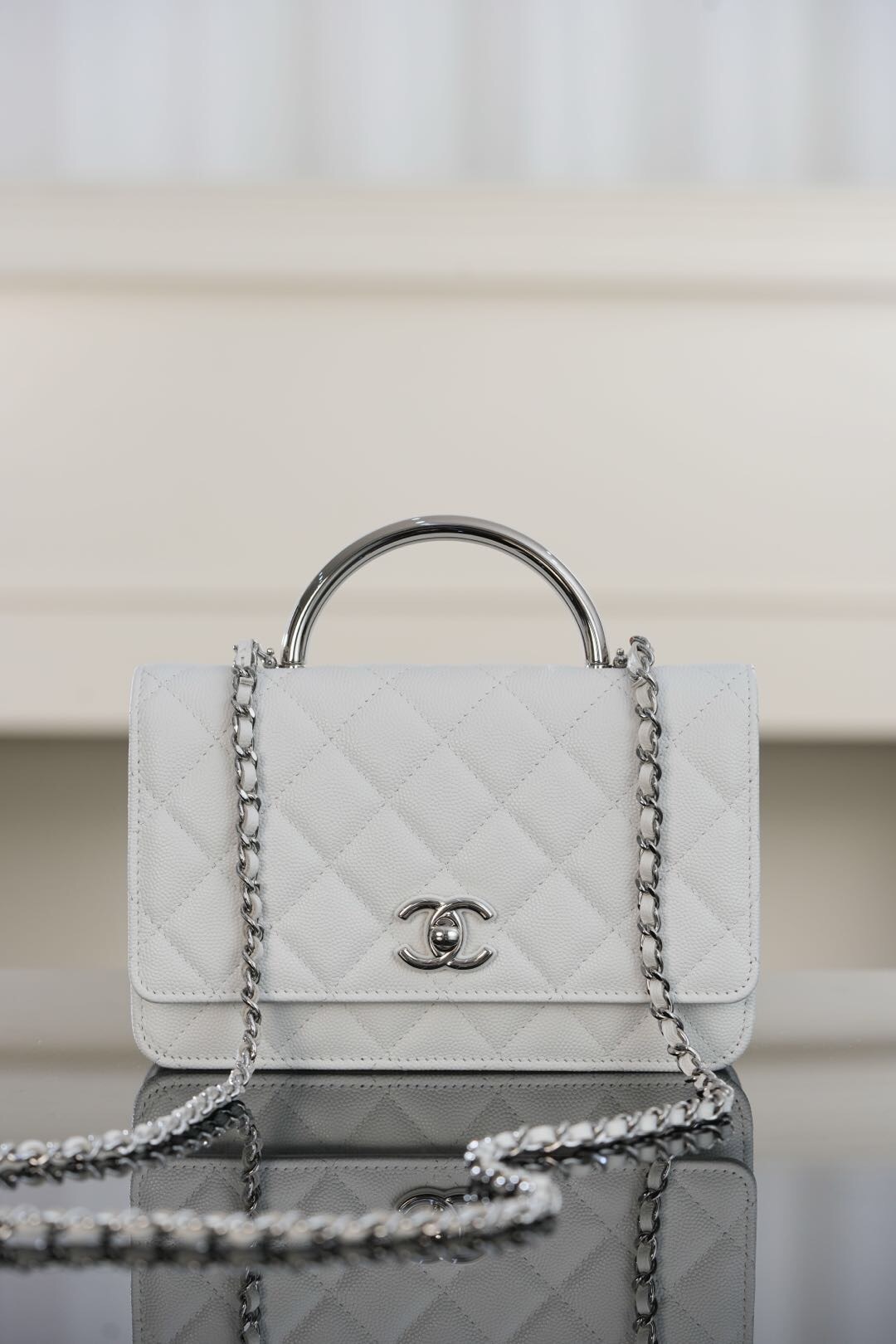 Chanel Mini Flap Bag with a Top Handle with conic interlocking CC logo and a chain-link strap