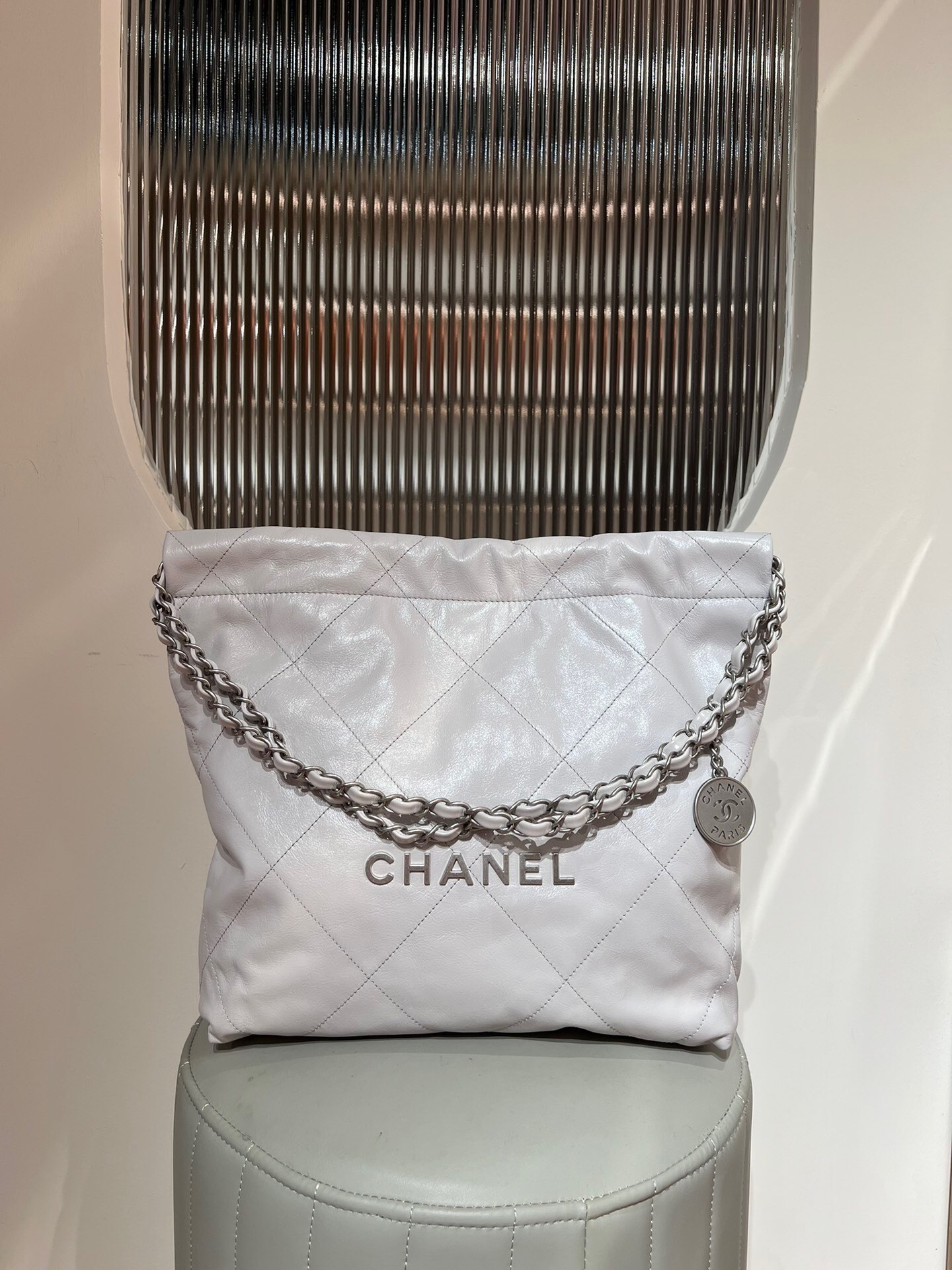 Chanel 22 handbag in quilted white calfskin with a silver-tone chain strap