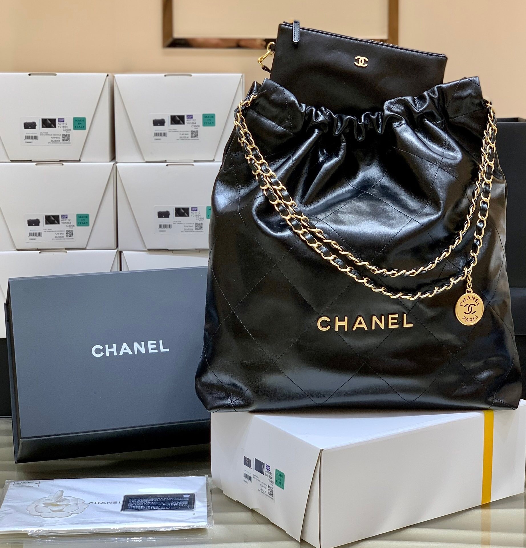Chanel 22 handbag black shiny calfskin with gold-tone metal hardware.