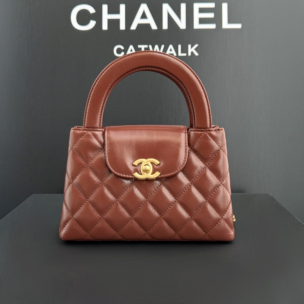 Chanel Kelly handbag quilted mini bag with a top handle and a signature interlocking CC turn-lock fastening.