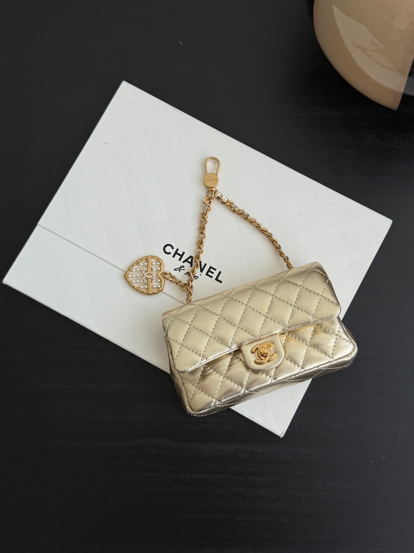 Chanel Classic Mini Classic Flap Bag or Mini Flap Bag, in a gold color with a quilted pattern.