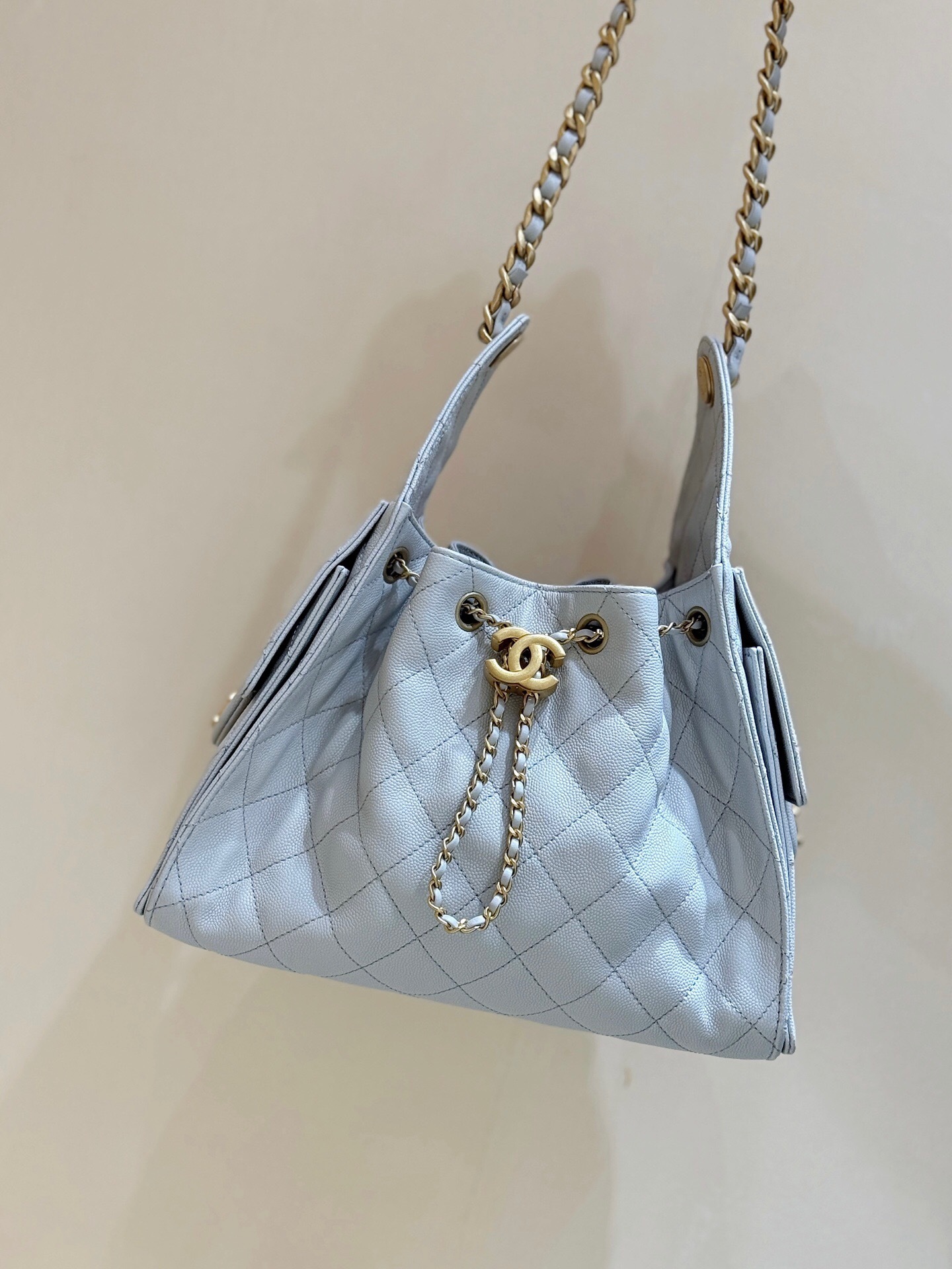 Chanel 25 handbag Maxi Hobo Bag, in a light-colored, quilted leather.