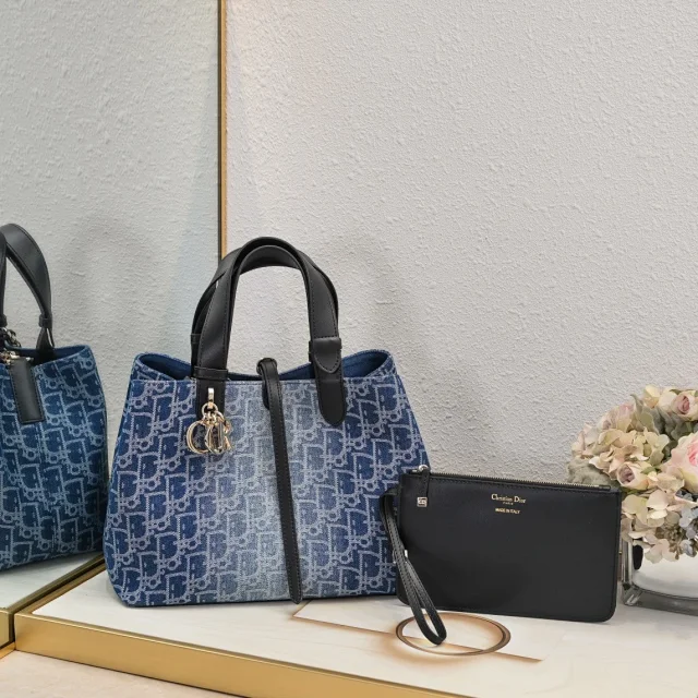 Dior Toujours bag in a blue Dior Oblique pattern, accompanied by a black clutch