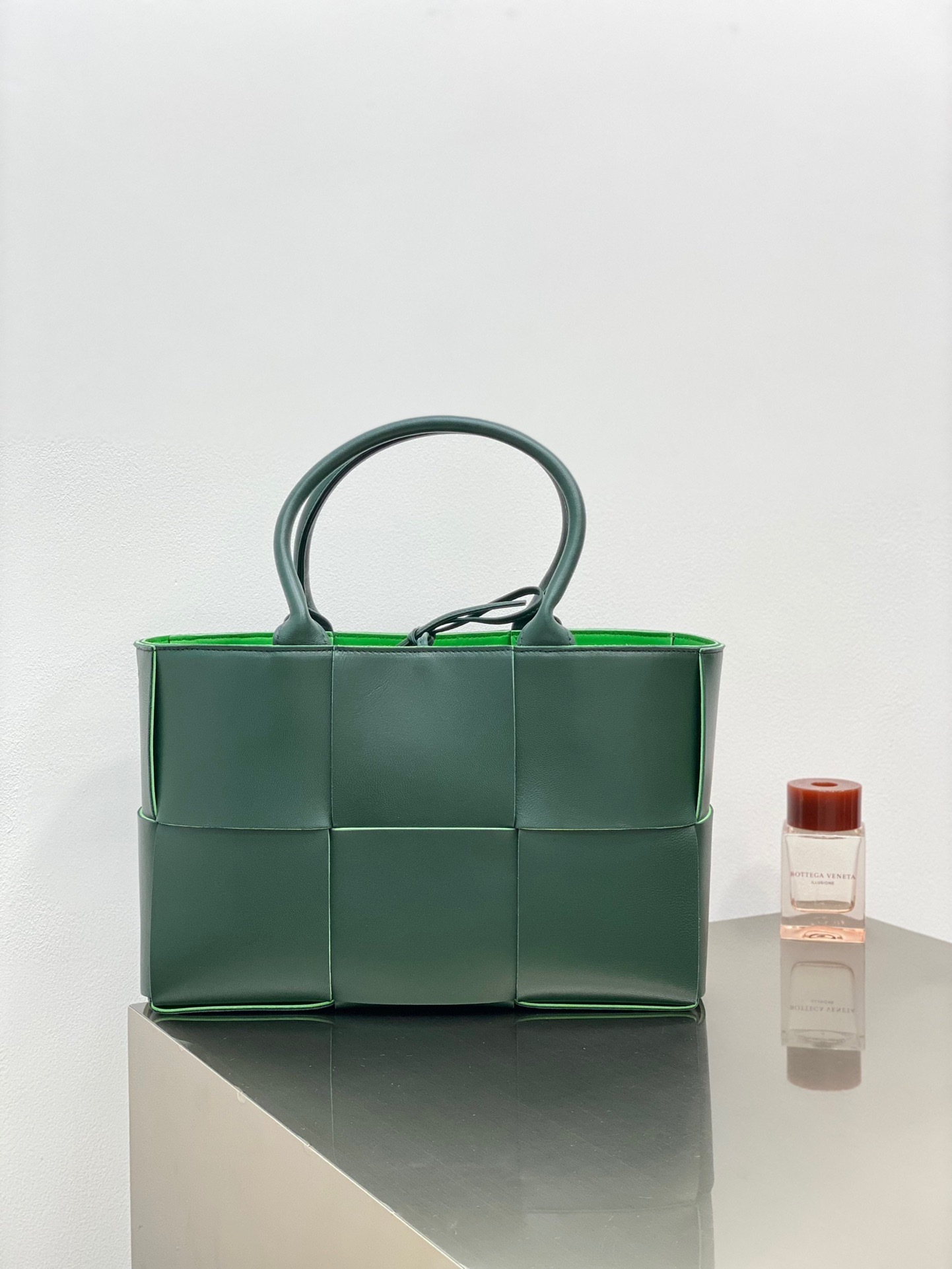 Bottega Veneta Medium Arco Tote Bag in a green color with a lambskin bonded intreccio lining