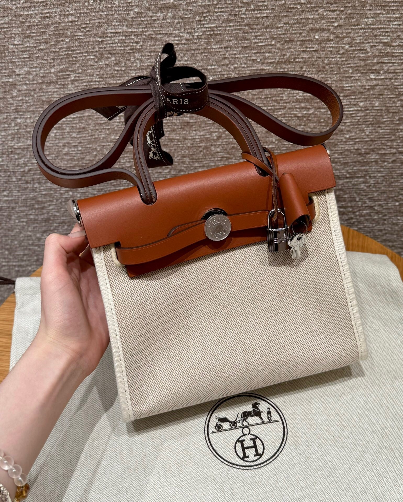 Hermes Herbag, a handbag with a canvas body and a leather flap top handle