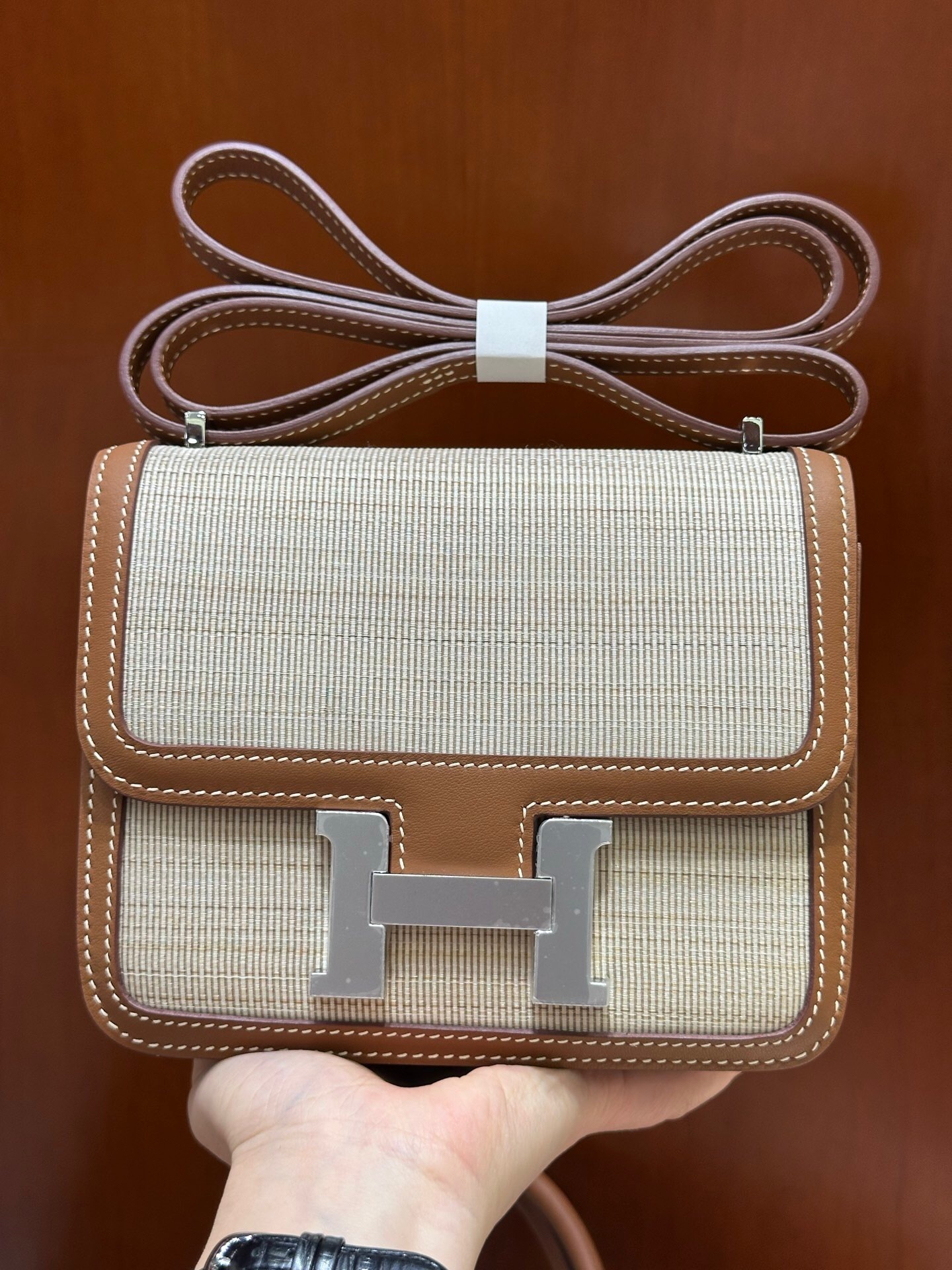 Hermes Constance bag in a neutral color with brown leather trim and a silver H-clasp