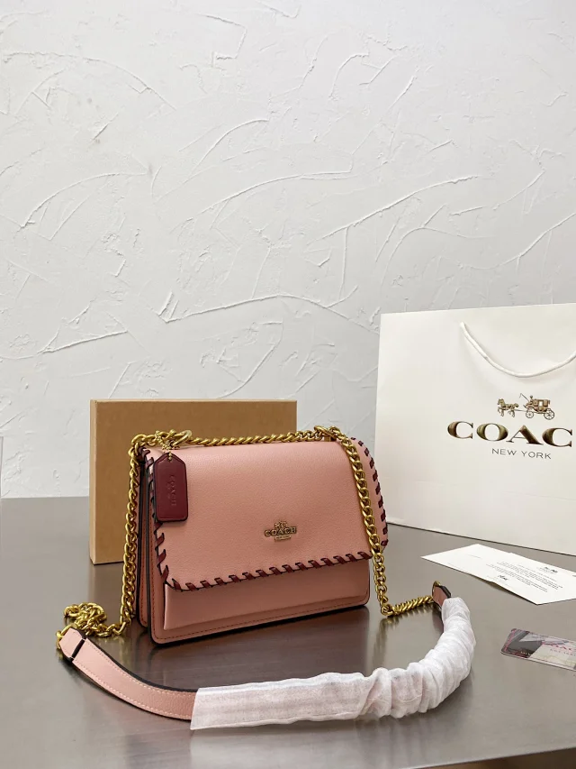 Coach Klare crossbody bag in beige or blush pink leather with a gold chain strap and whipstitch detailing