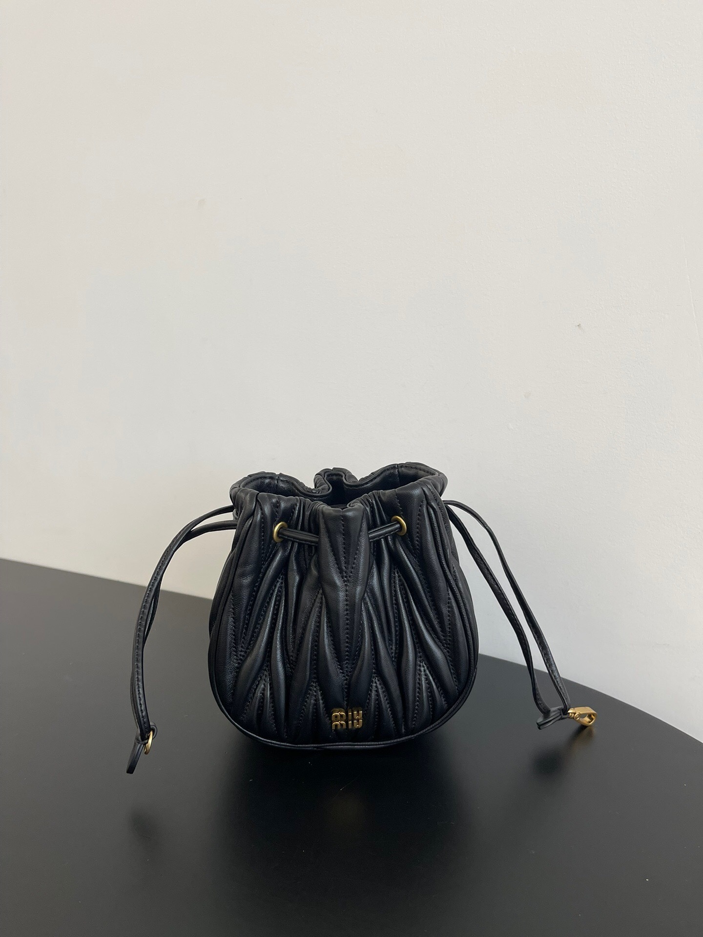 Miu Miu black matelasse leather bucket bag with a drawstring closure