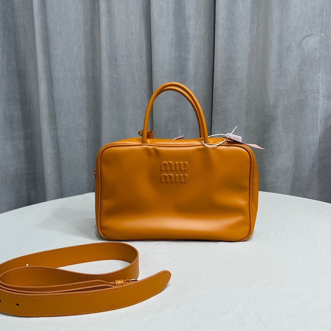Miu Miu logo-embossed leather top handle bag in a cinnamon or caramel brown color