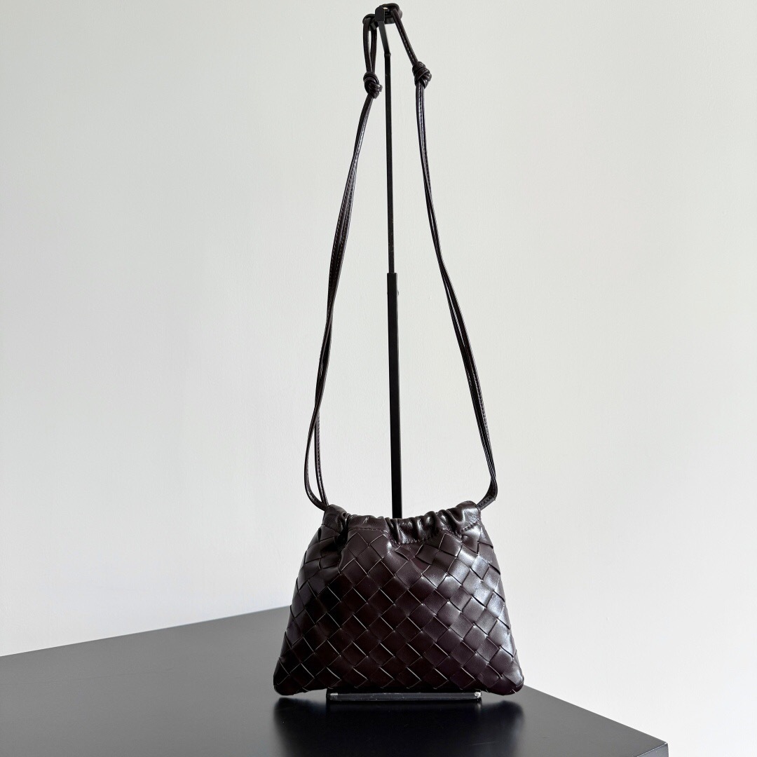 Bottega Veneta leather drawstring pouch in a dark brown color, featuring the brand's signature Intrecciato woven design
