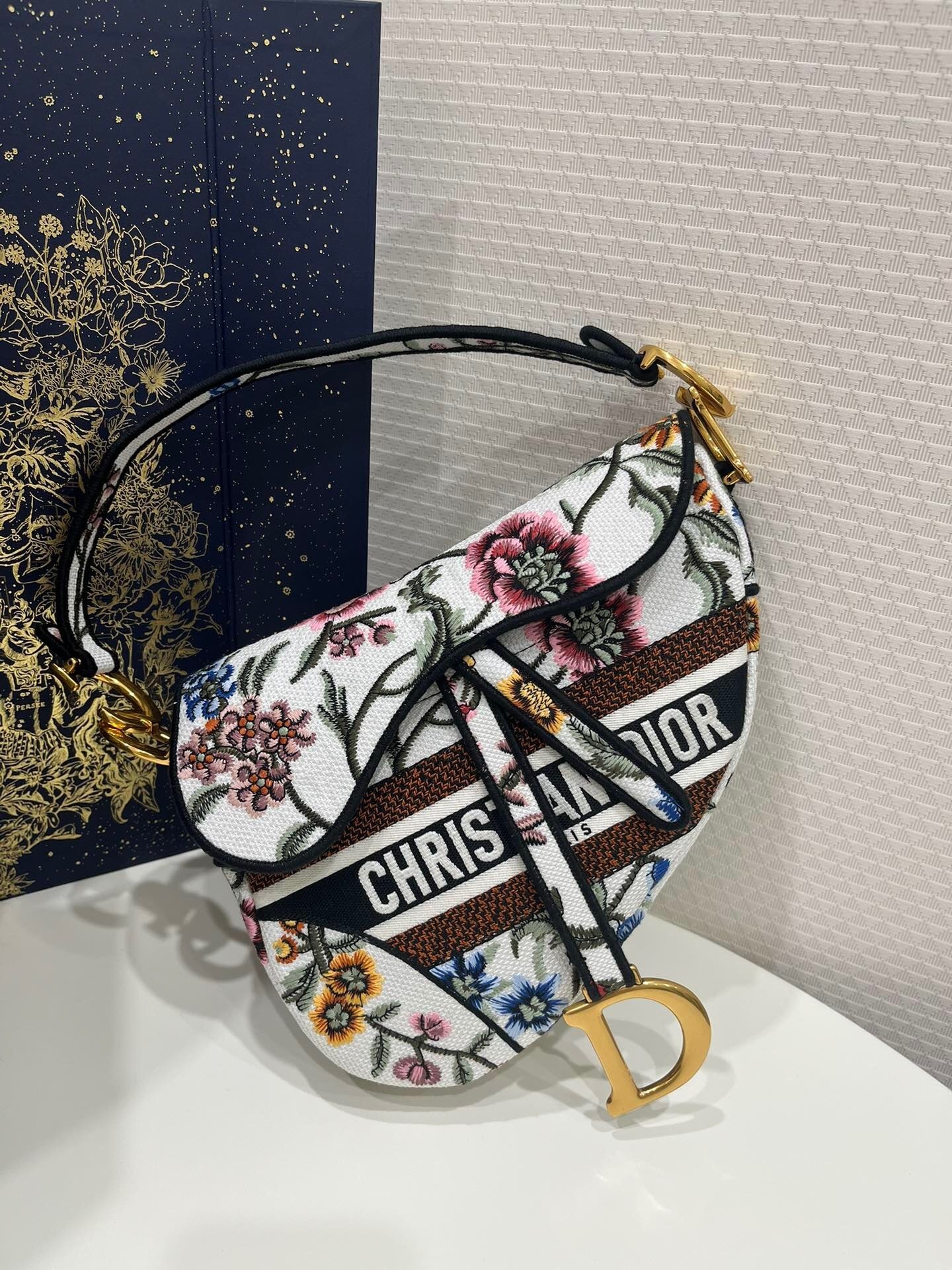Christian Dior Saddle Bag in white multicolor Dior Petites Fleurs embroidery.