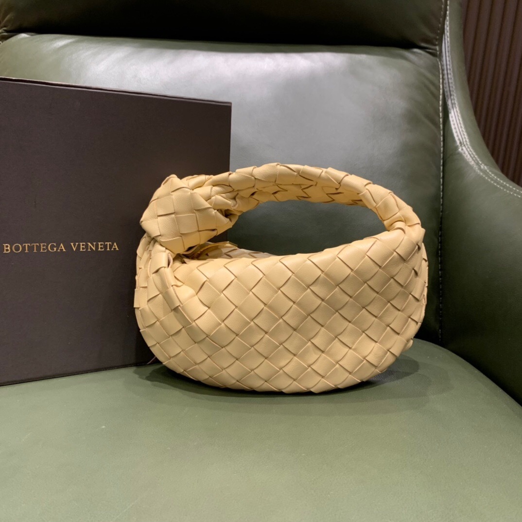 Bottega Veneta Mini Jodie bag in a light yellow or beige intrecciato-woven lambskin leather with a knotted top handle