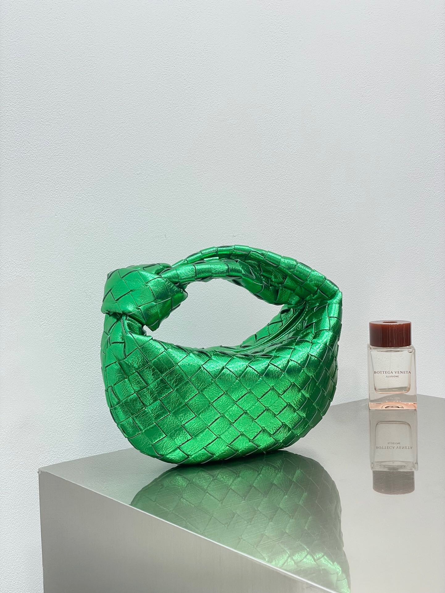 Bottega Veneta Mini Jodie bag in leather with the signature Intrecciato weave and knotted handle metallic green
