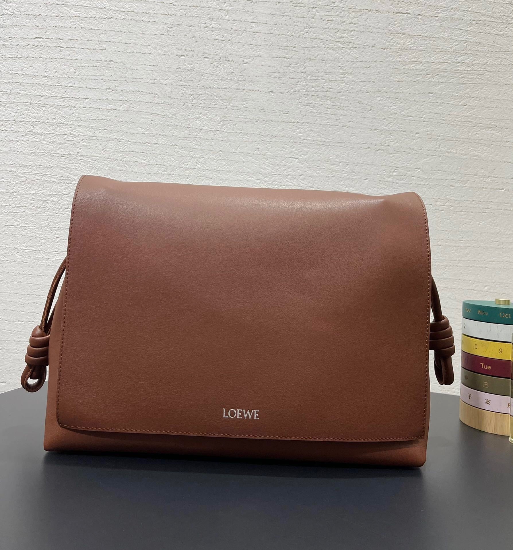 Loewe Flamenco satchel bag in brown calfskin leather, featuring signature coiled knots on the side drawstrings