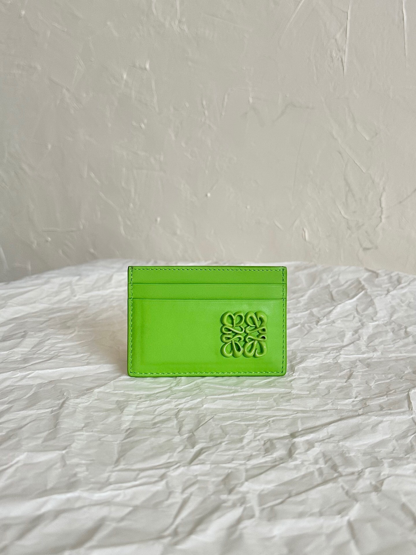 Loewe Inflated Anagram leather card holder in a light green or "green bean" color