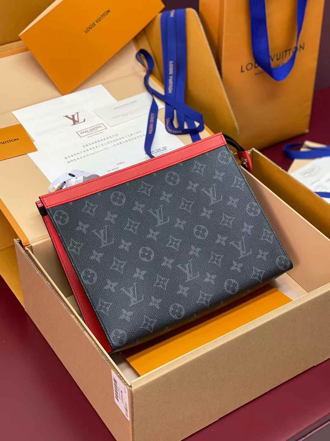 LV Pochette Voyage MM in Monogram Eclipse coated canvas with red trim