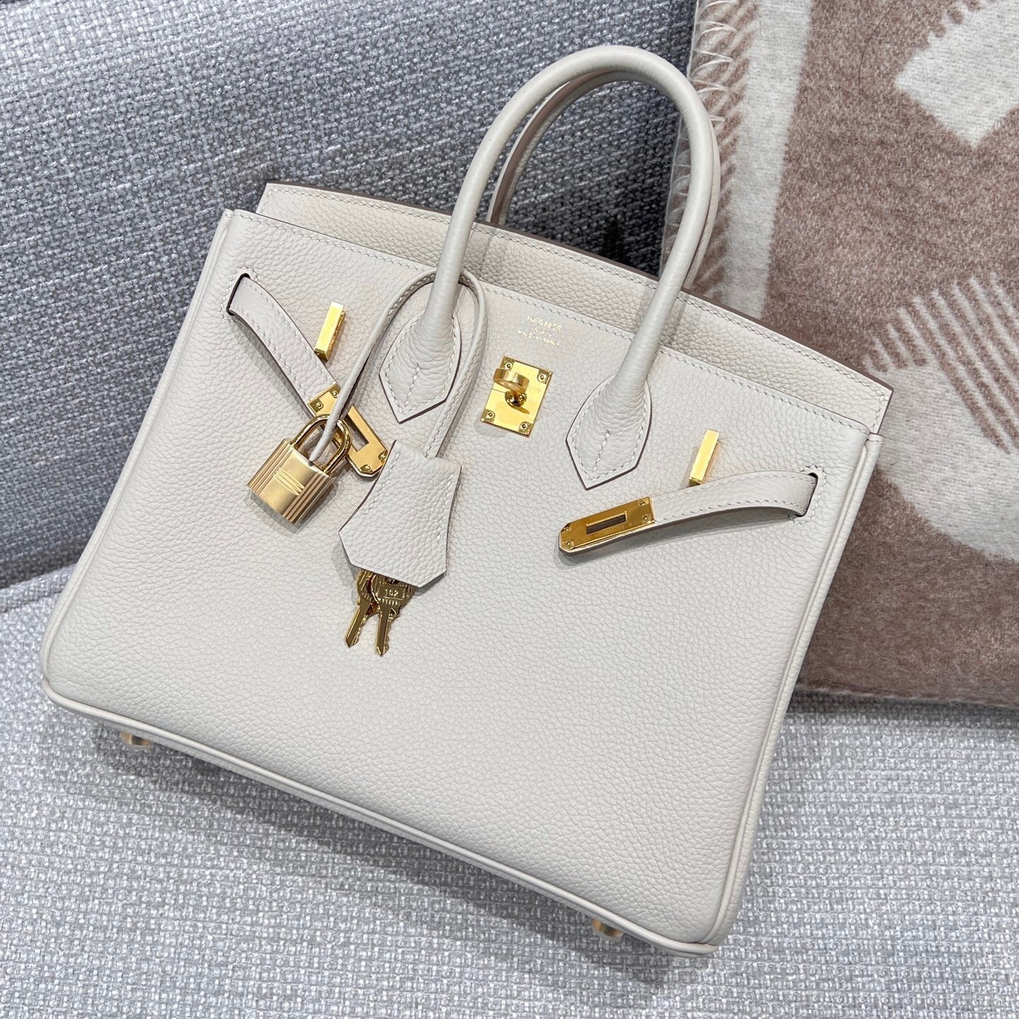 Hermes Birkin 25 Tote bag in Togo leather with gold hardware, likely in a light gray or white
