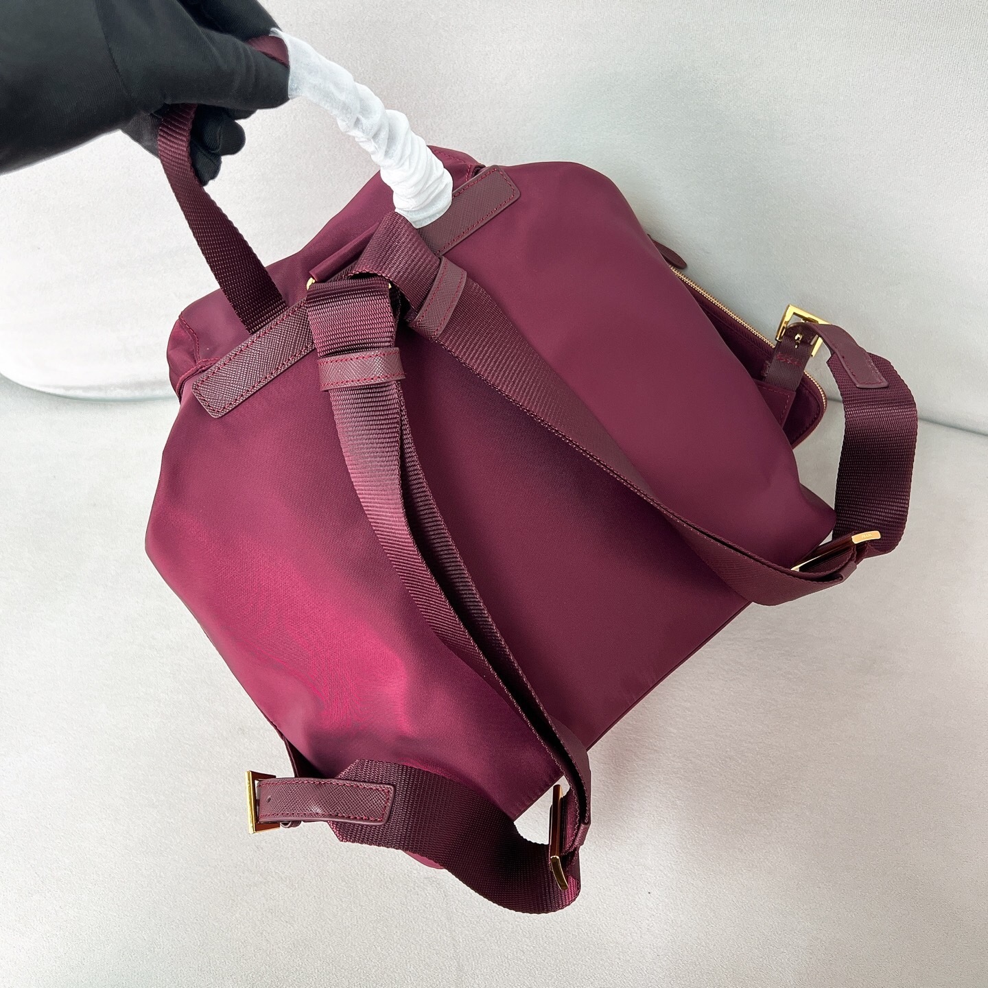 Prada Re-Edition 1978 Re-Nylon small or medium backpack in a burgundy/brandy red color with gold-tone hardware