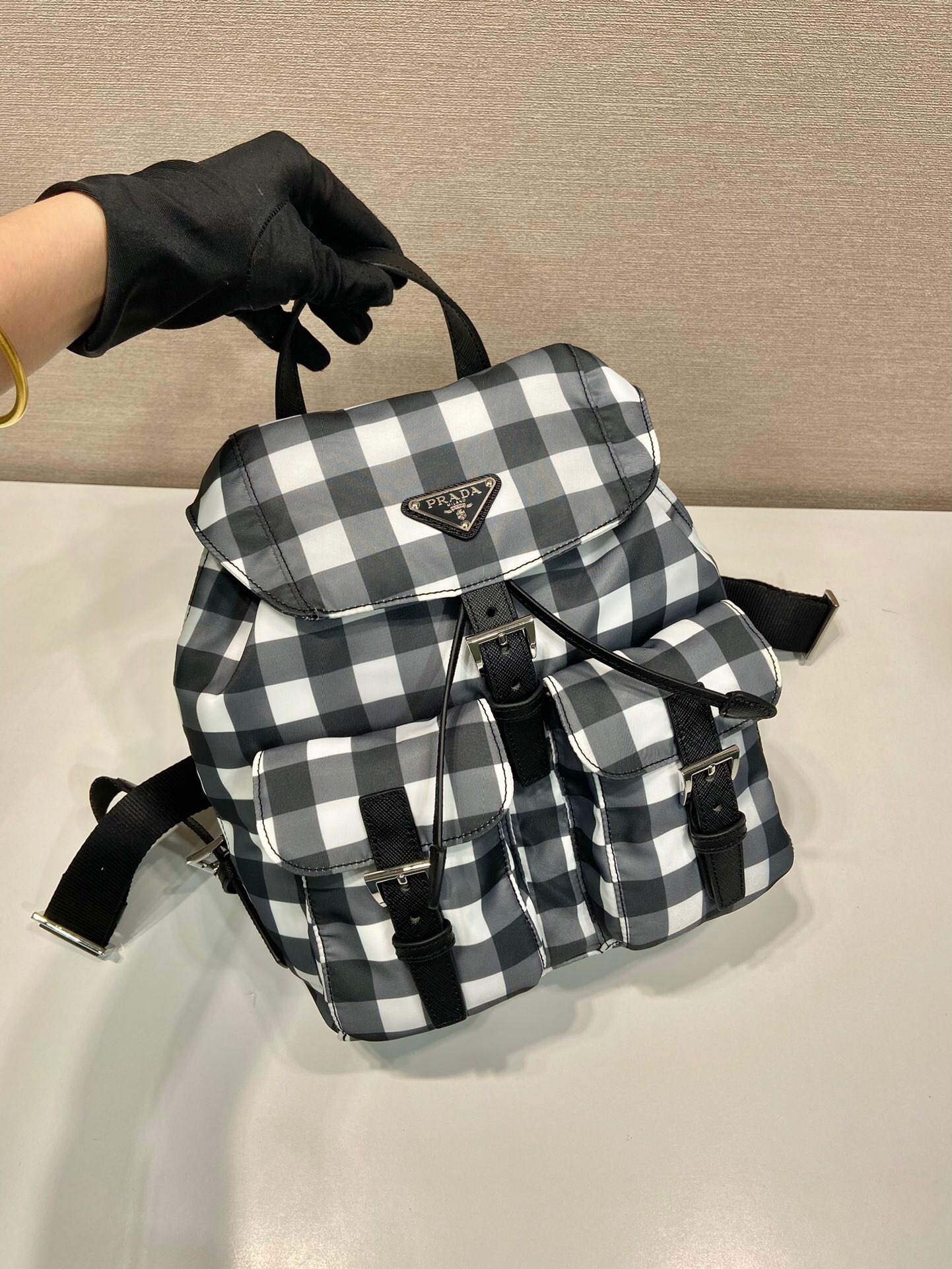 Prada Re-Nylon backpack in a black and white gingham or checked pattern