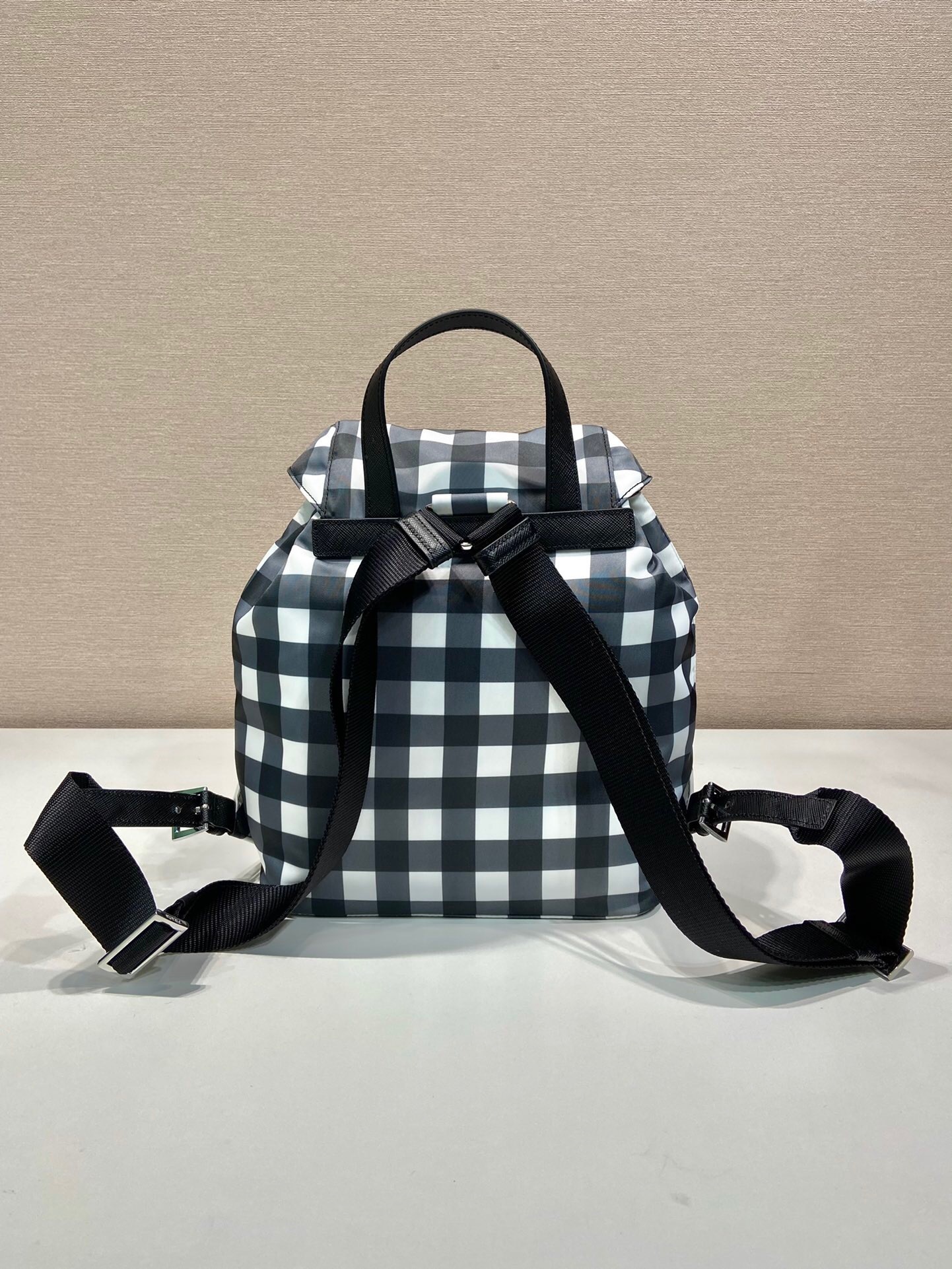 Prada Re-Nylon backpack in a black and white gingham or checked pattern