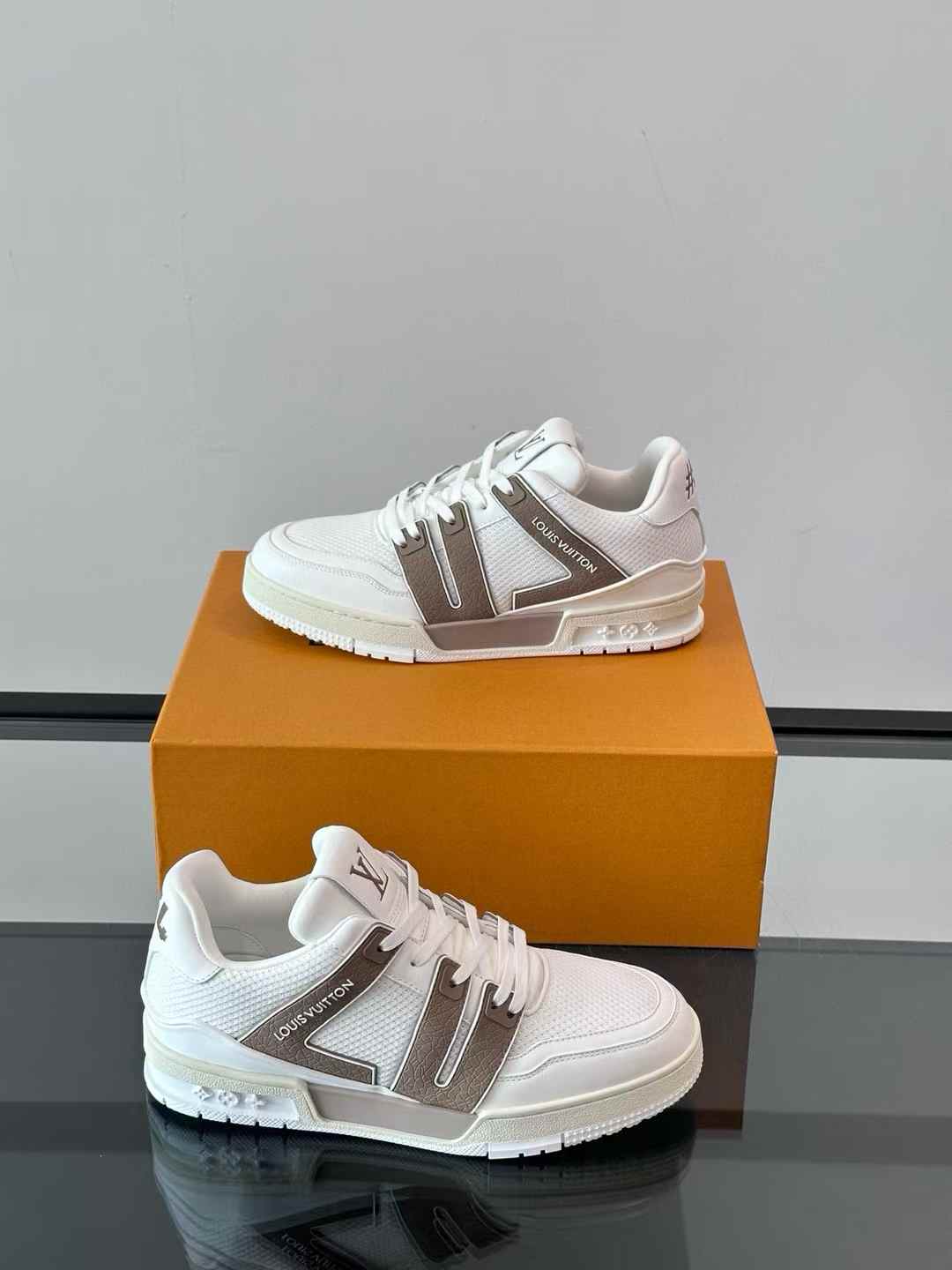 lv Trainer sneaker in a white and grey/taupe color grained calf leather and rubber signatures on the side and back