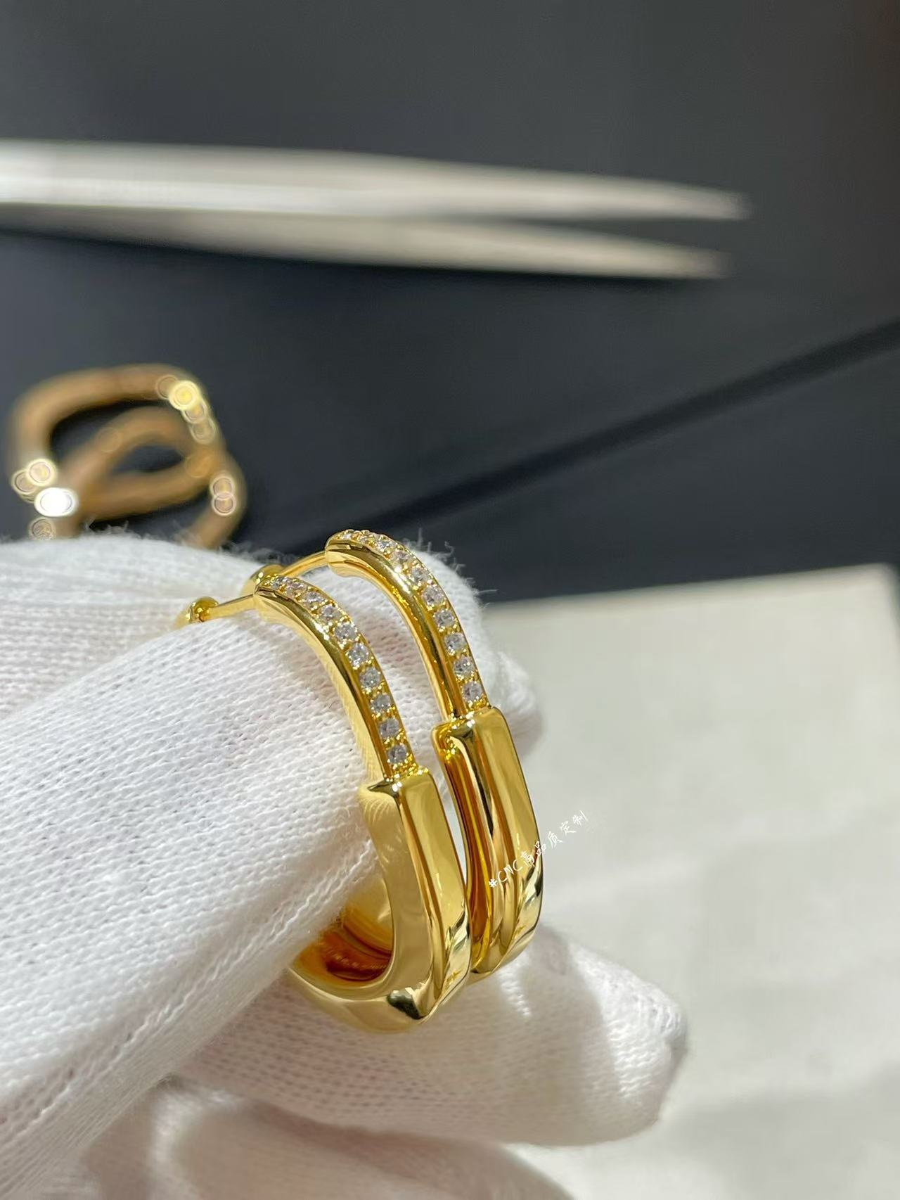 cartier a pair of gold-toned hoop earrings with diamond accents