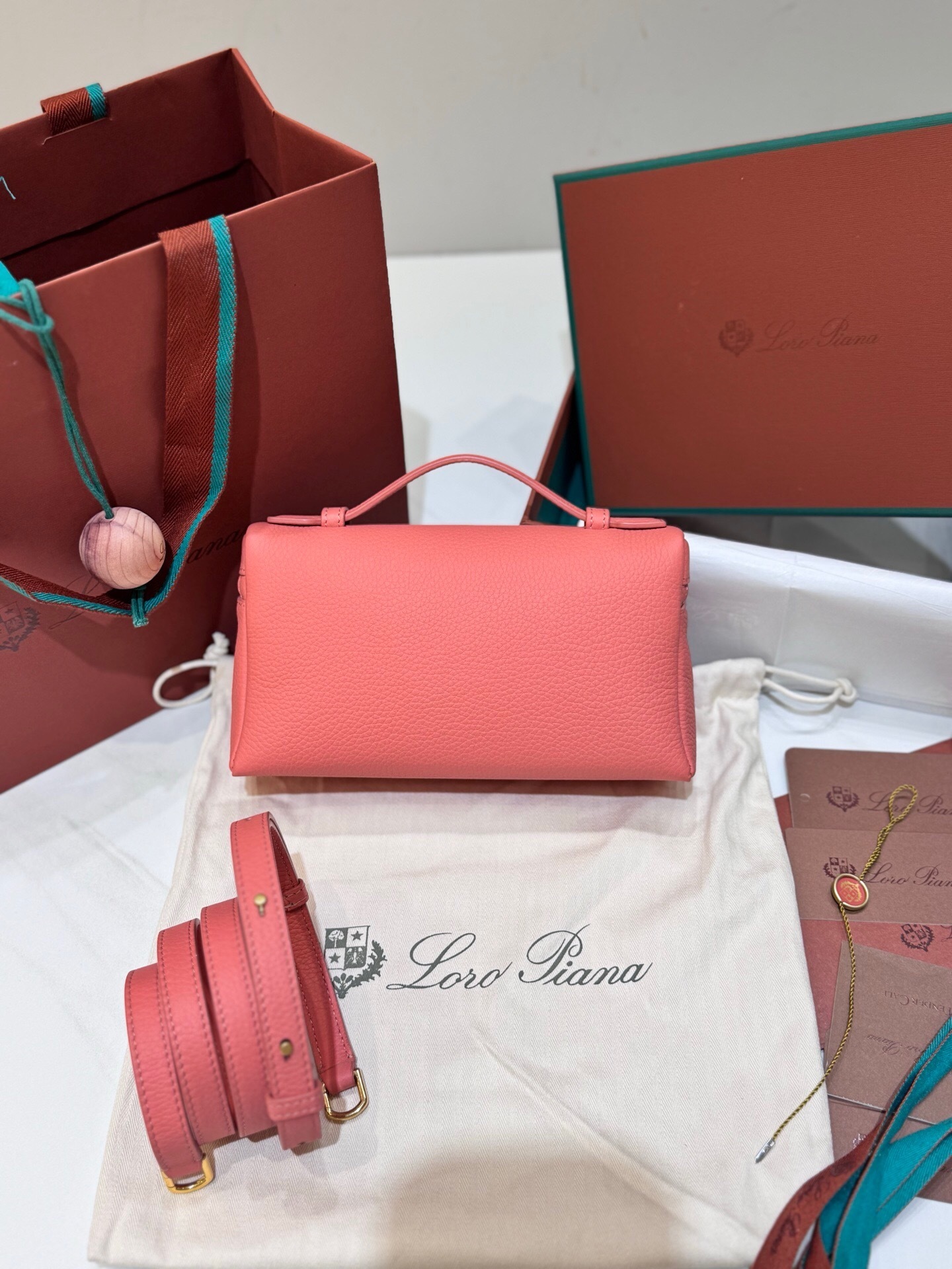 Loro Piana Extra Pocket L19 pouch in calf leather, possibly in a flamingo or salmon pink color