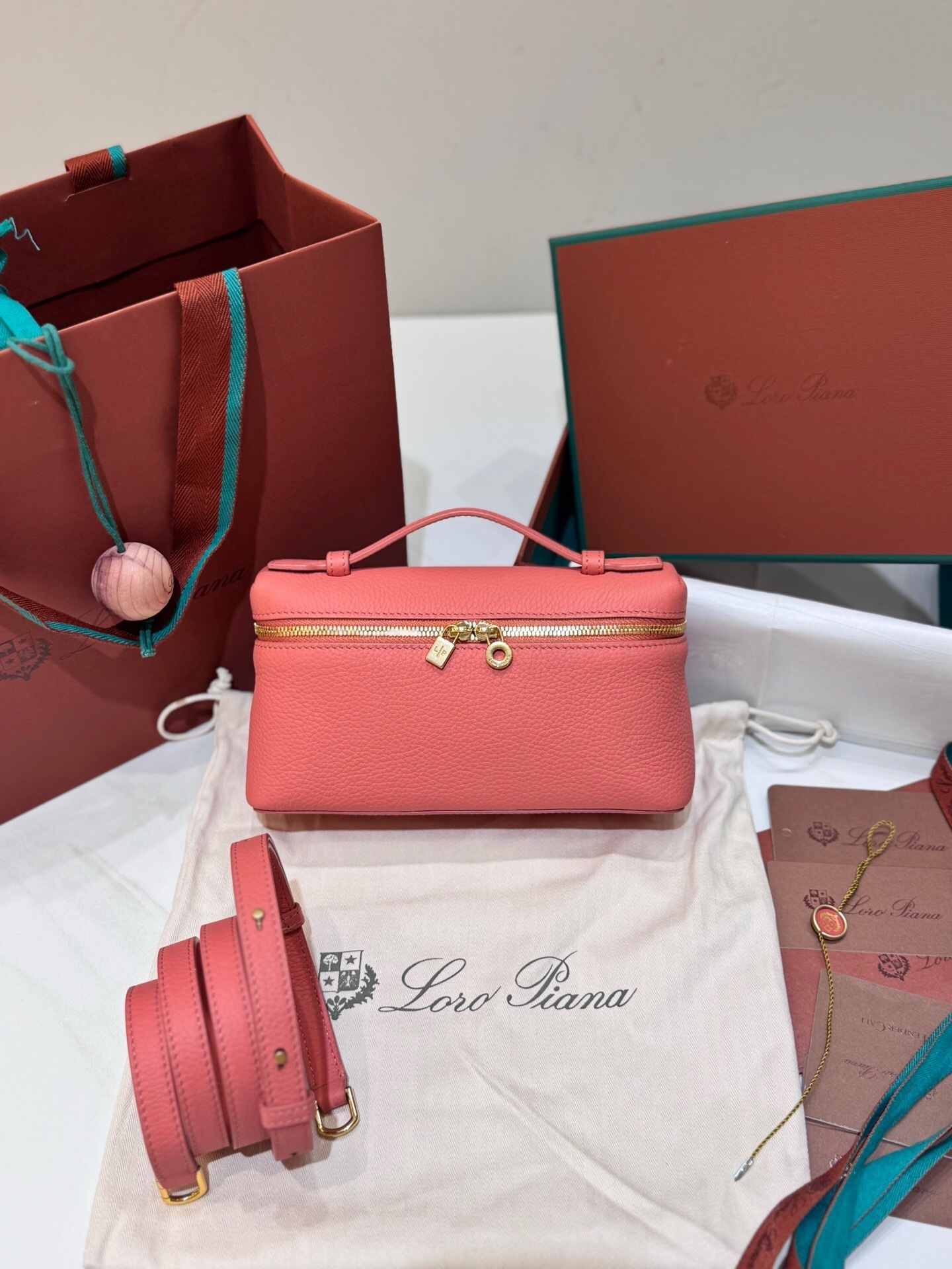 Loro Piana Extra Pocket L19 pouch in calf leather, possibly in a flamingo or salmon pink color