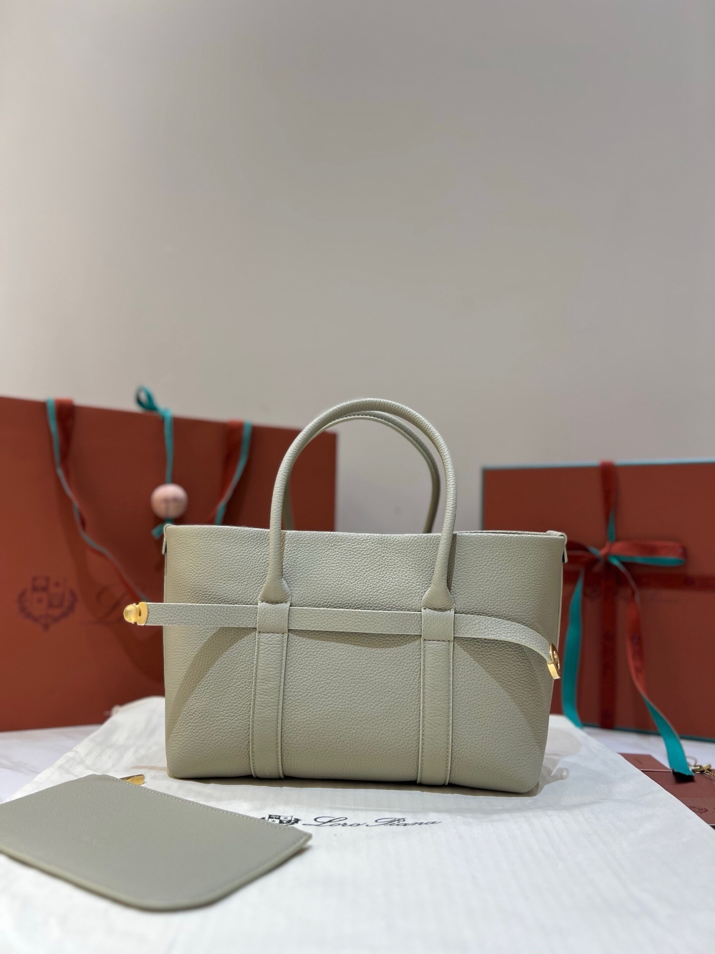 Loro Piana Ghiera Shopper Small tote bag in fine-grained calfskin leather, possibly in the "Light Travertine" color, featuring gold-tone hardware and a detachable inner pouch