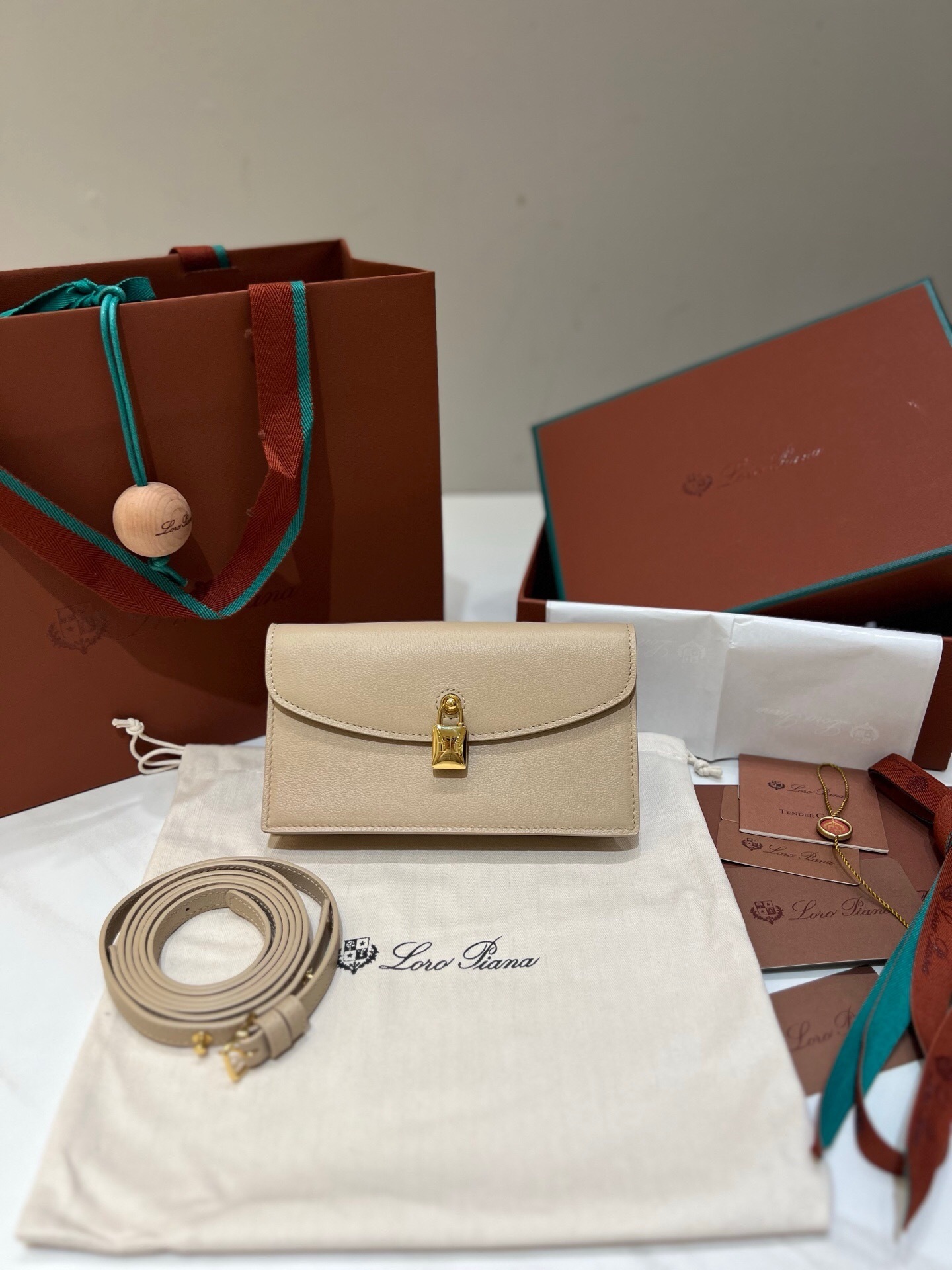 Loro Piana Extra Pochette in calfskin leather with a magnetic closure and an adjustable, detachable shoulder strap