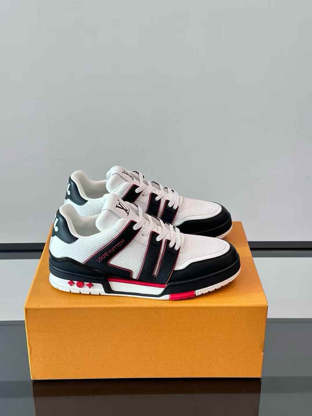 LV Trainer sneaker in a black and white colorway with red accents