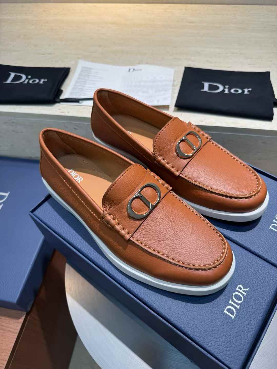 Dior Granville loafers in a brown leather with a white rubber sole and a palladium-finish brass CD Icon buckle