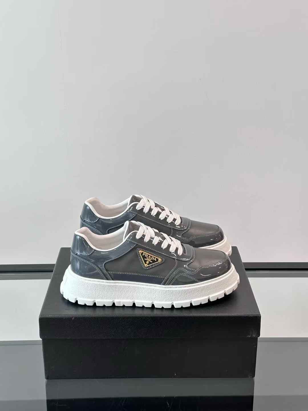 Prada brushed leather lace-up shoe in a dark grey or black color with a white rubber sole