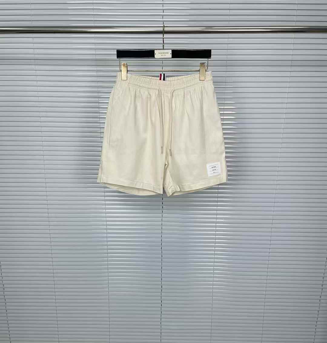 Thom Browne shorts with a drawstring waist, side pockets, and the signature grosgrain loop tab on the rear