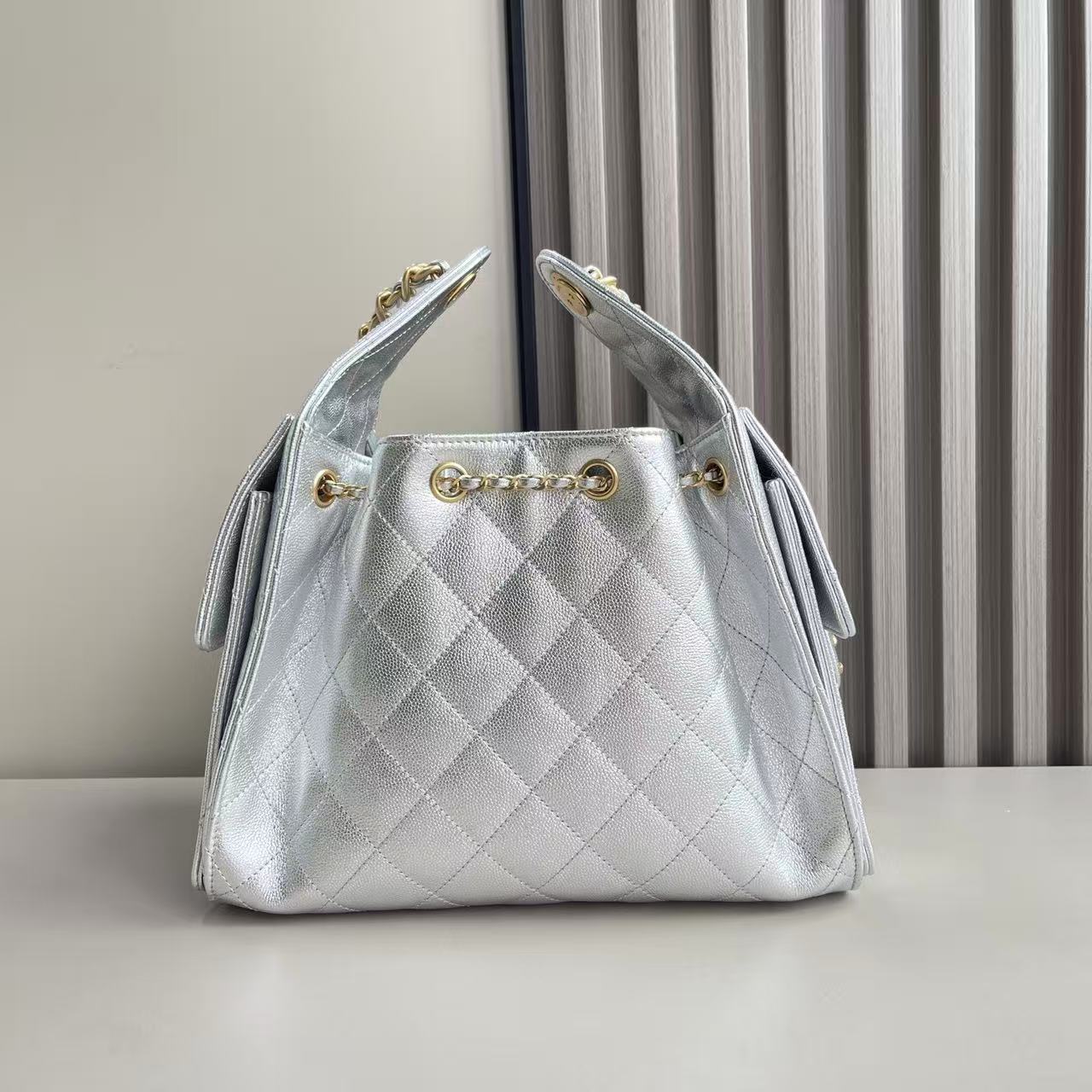 Chanel 25 small handbag in metallic silver grained calfskin leather with gold-tone metal hardware
