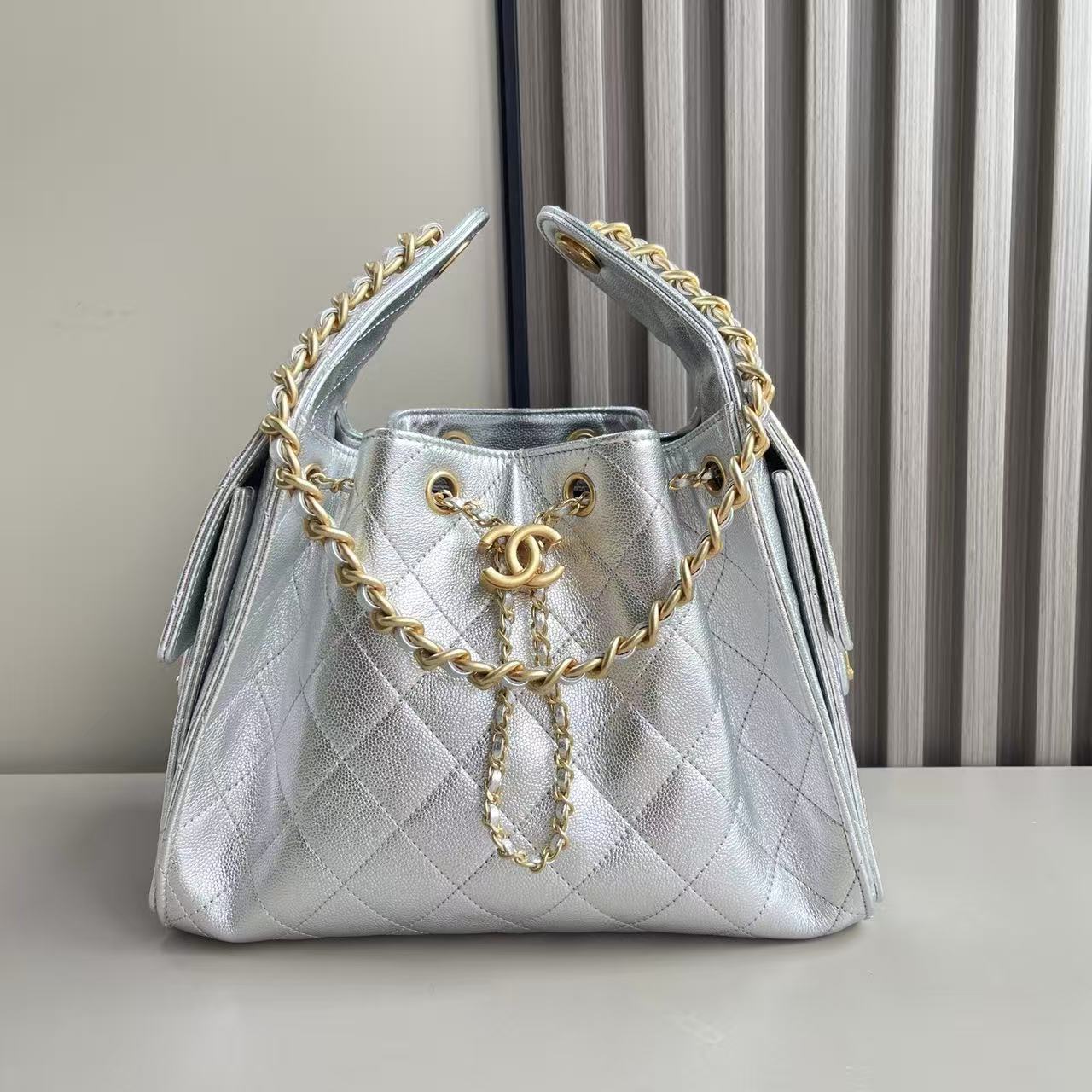 Chanel 25 small handbag in metallic silver grained calfskin leather with gold-tone metal hardware