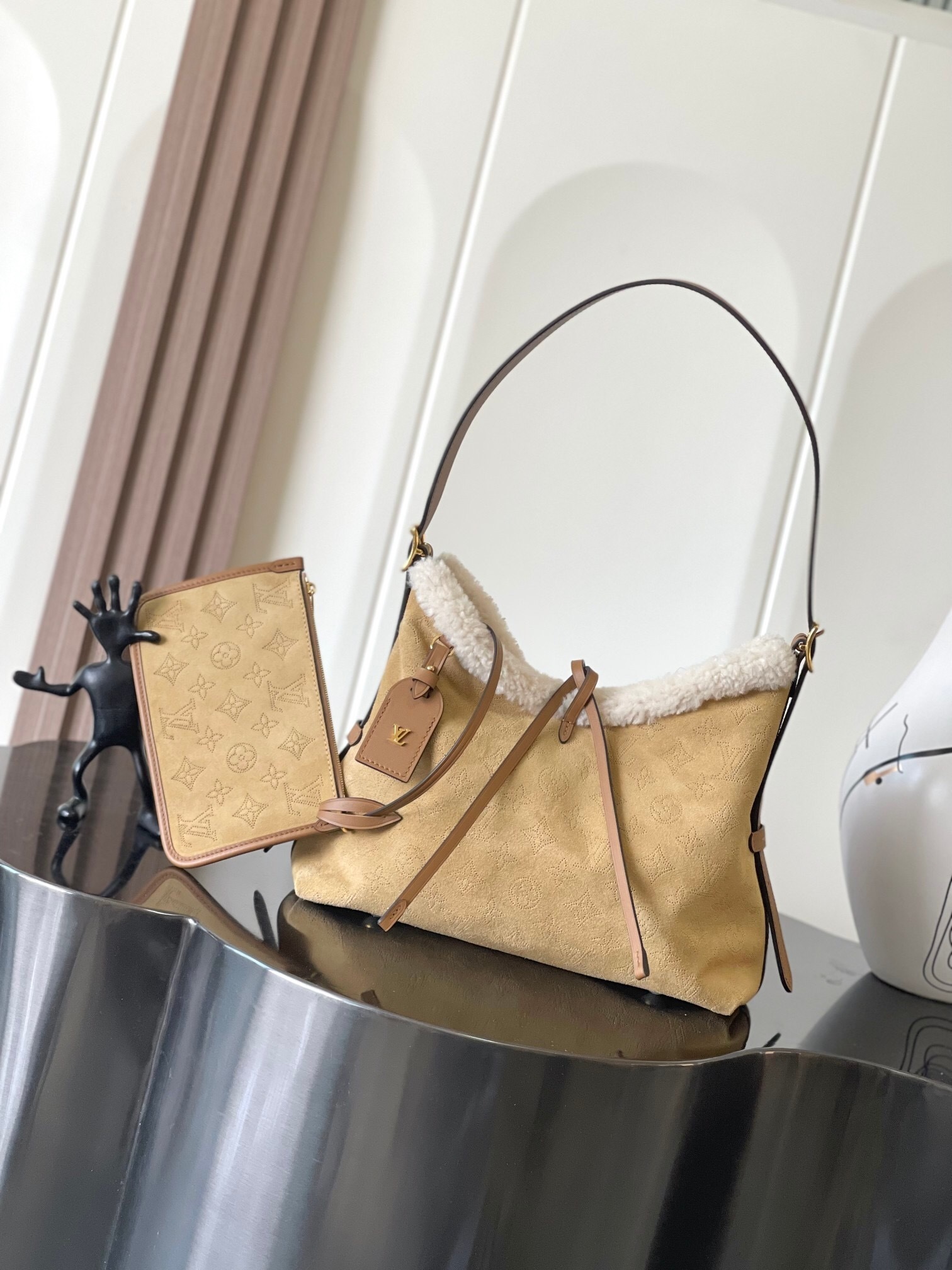 Louis Vuitton CarryAll PM bag in a tan/beige material, possibly suede or a variation of the Monogram Empreinte leather with a shearling trim