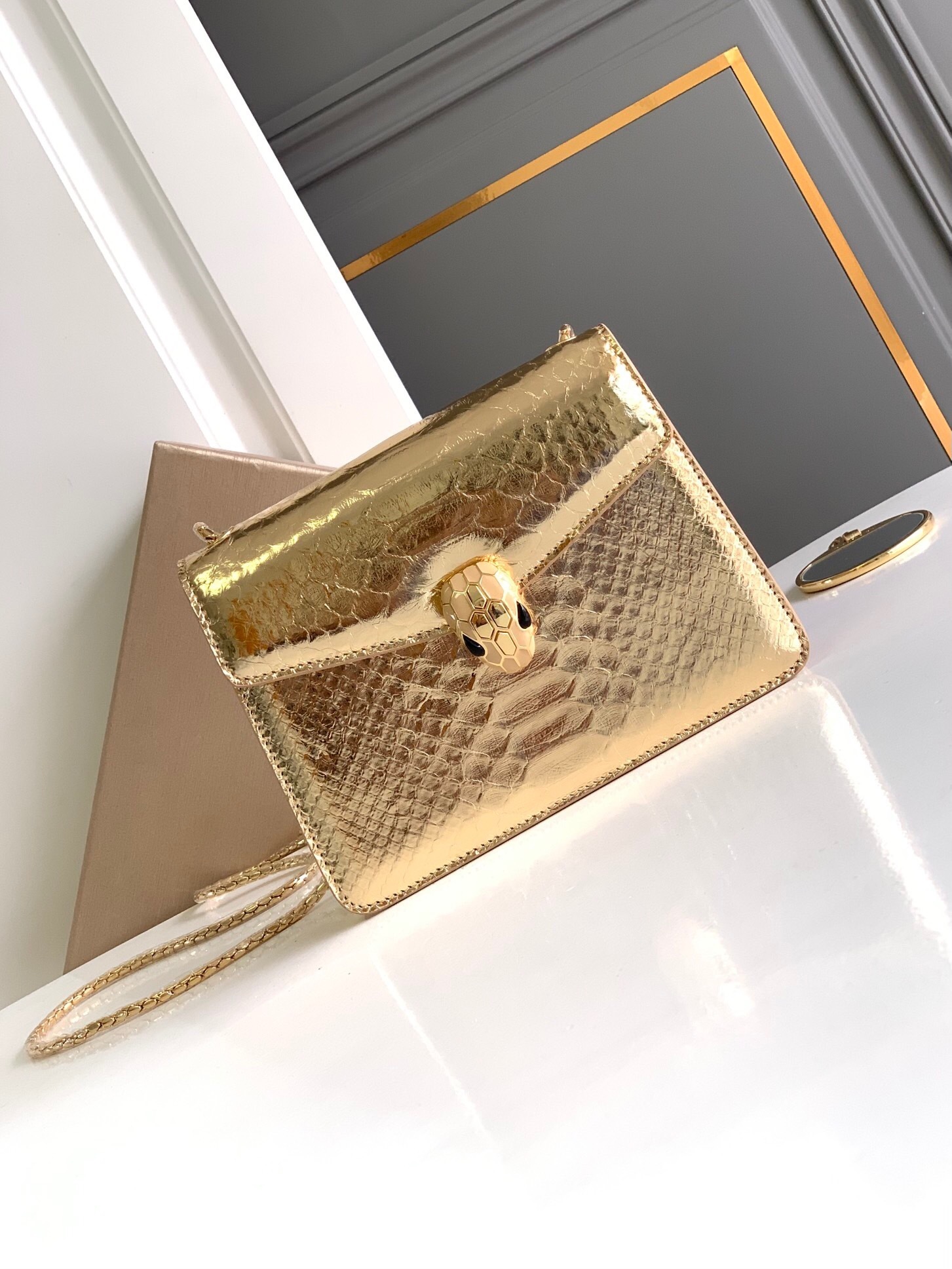 Bvlgari Serpenti Forever small crossbody bag in gold ostrich leather or striated calf leather, featuring the iconic magnetic snakehead closure and a snake body-shaped chain strap.