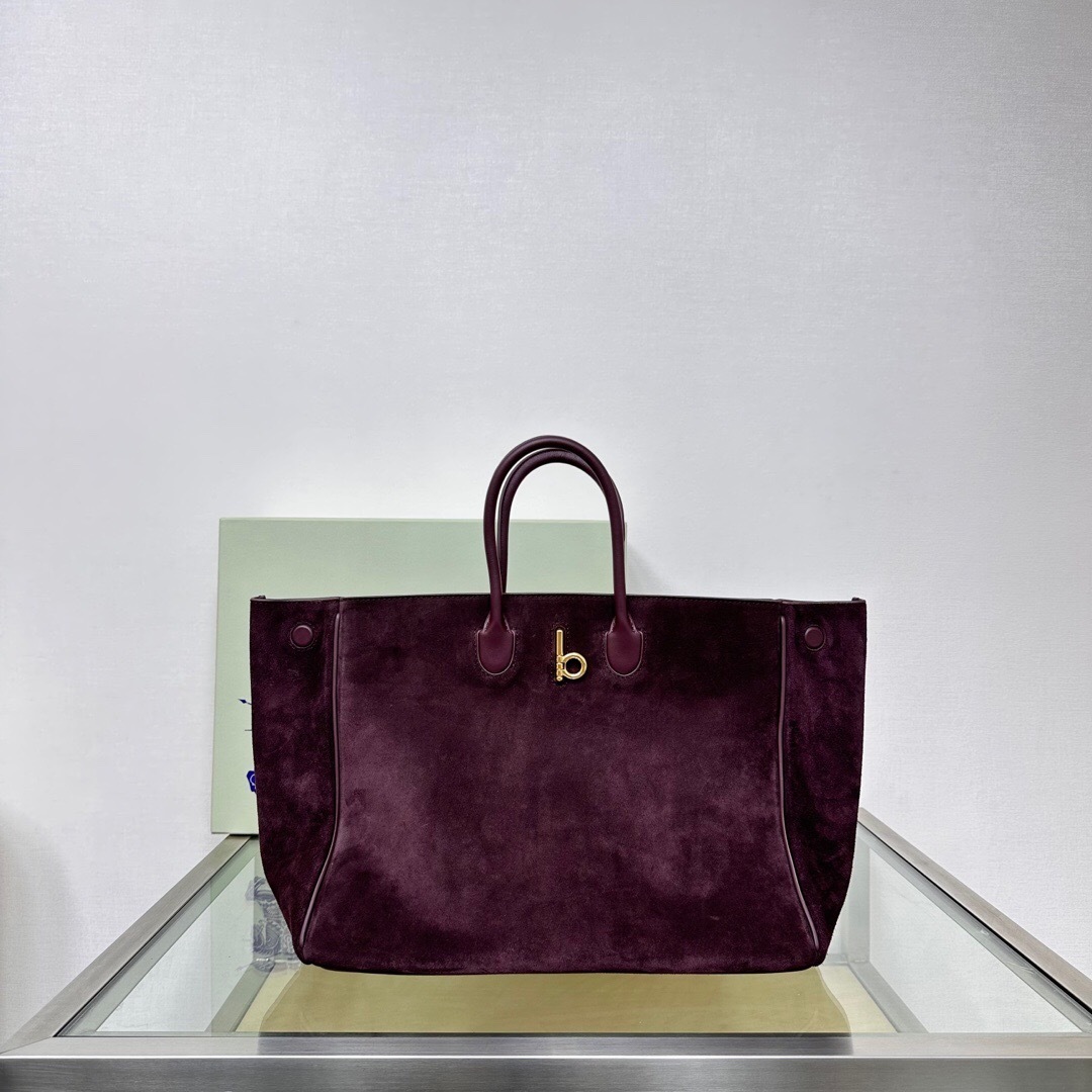 Burberry Rocking Horse suede tote bag in a dark brown or berry color with a "b" closure