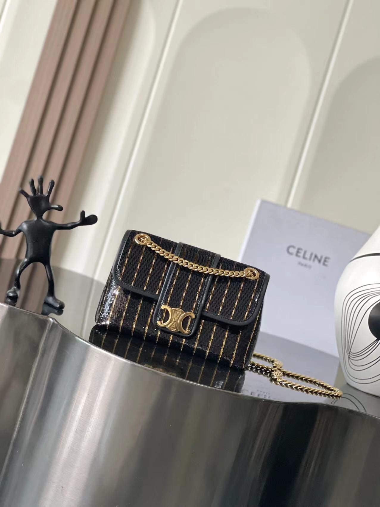 Celine Victoire bag in black with gold vertical stripes and a gold chain strap