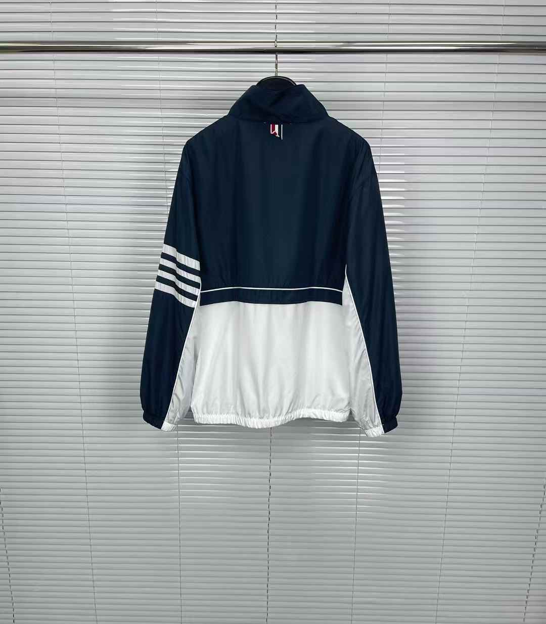 thom browne  track jacket in blue and white with a zip closure.