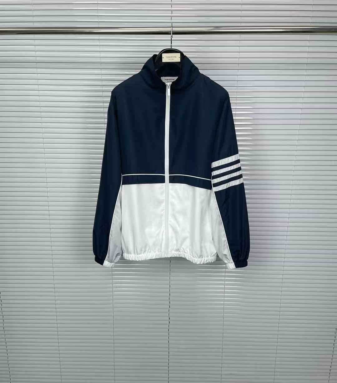 thom browne  track jacket in blue and white with a zip closure.